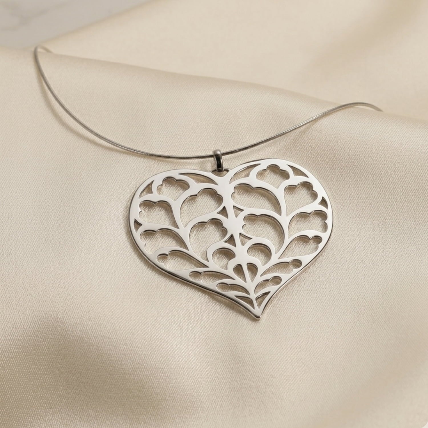 Sterling silver pendant with an intricate openwork heart design inspired by Yorkshire, suspended on a sleek omega collar, showcasing contemporary craftsmanship.