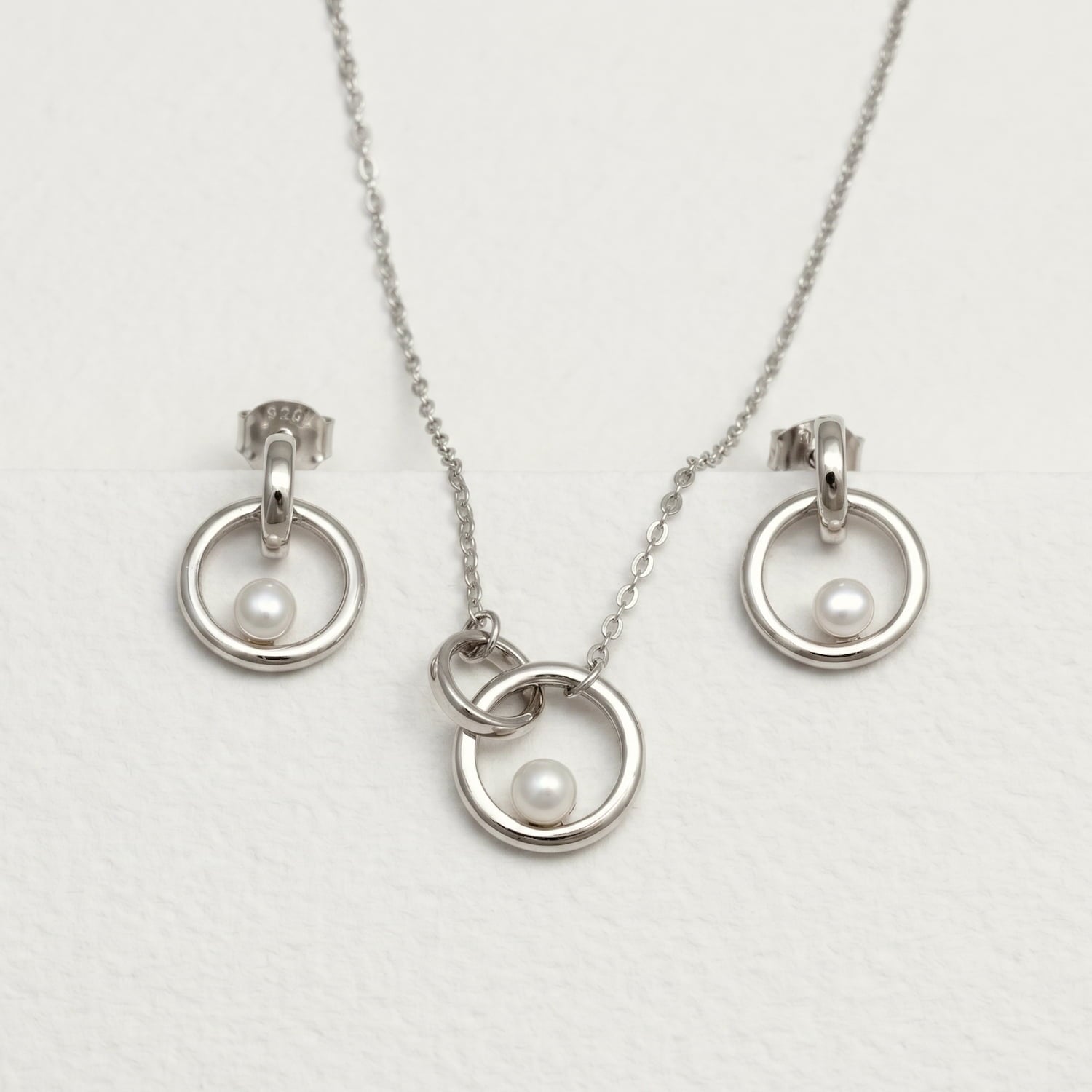 A sterling silver and freshwater pearl interlocking circles necklace and earring matching set.