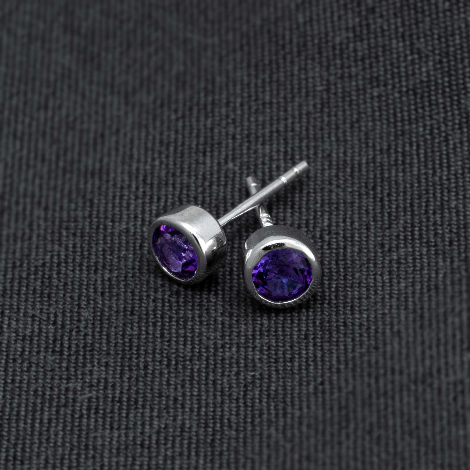 Pair of sterling silver stud earrings featuring deep purple amethyst gemstones, showcasing a classic and elegant design by an award-winning British jeweller.