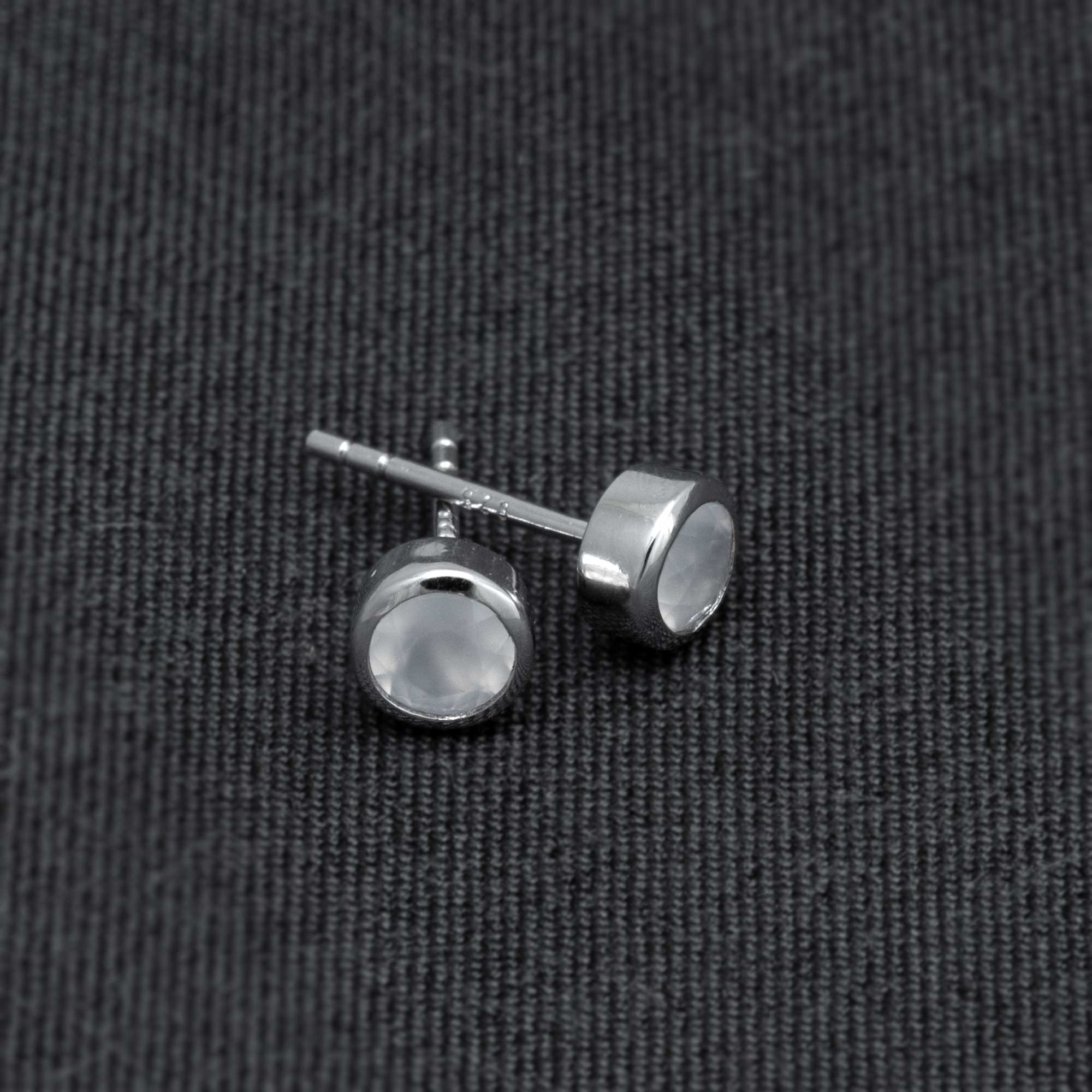 Pair of sterling silver stud earrings featuring round aqua chalcedony gemstones set in a polished bezel, highlighting refined British craftsmanship.