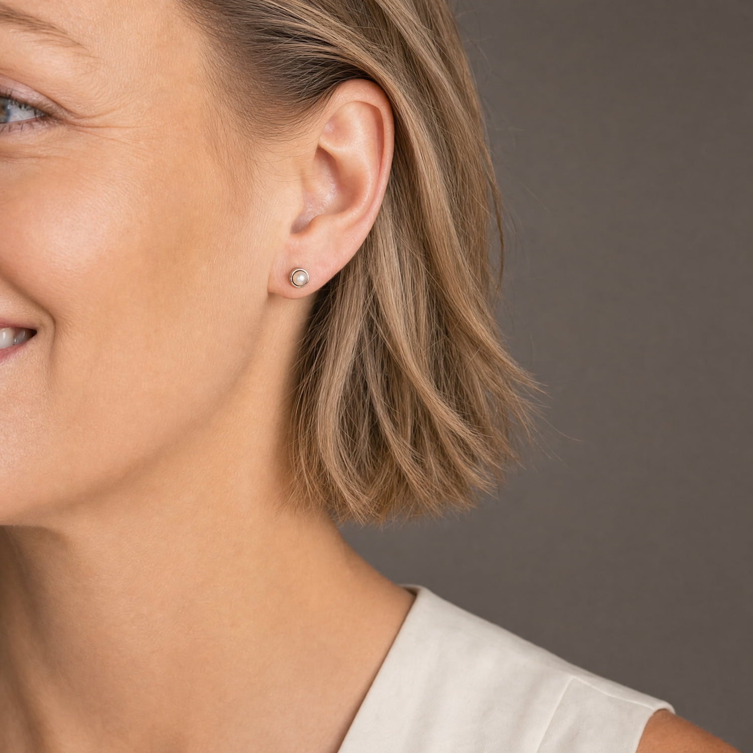 Delicate sterling silver stud earrings featuring smooth freshwater pearls, exemplifying refined British craftsmanship and a minimalist, elegant design.