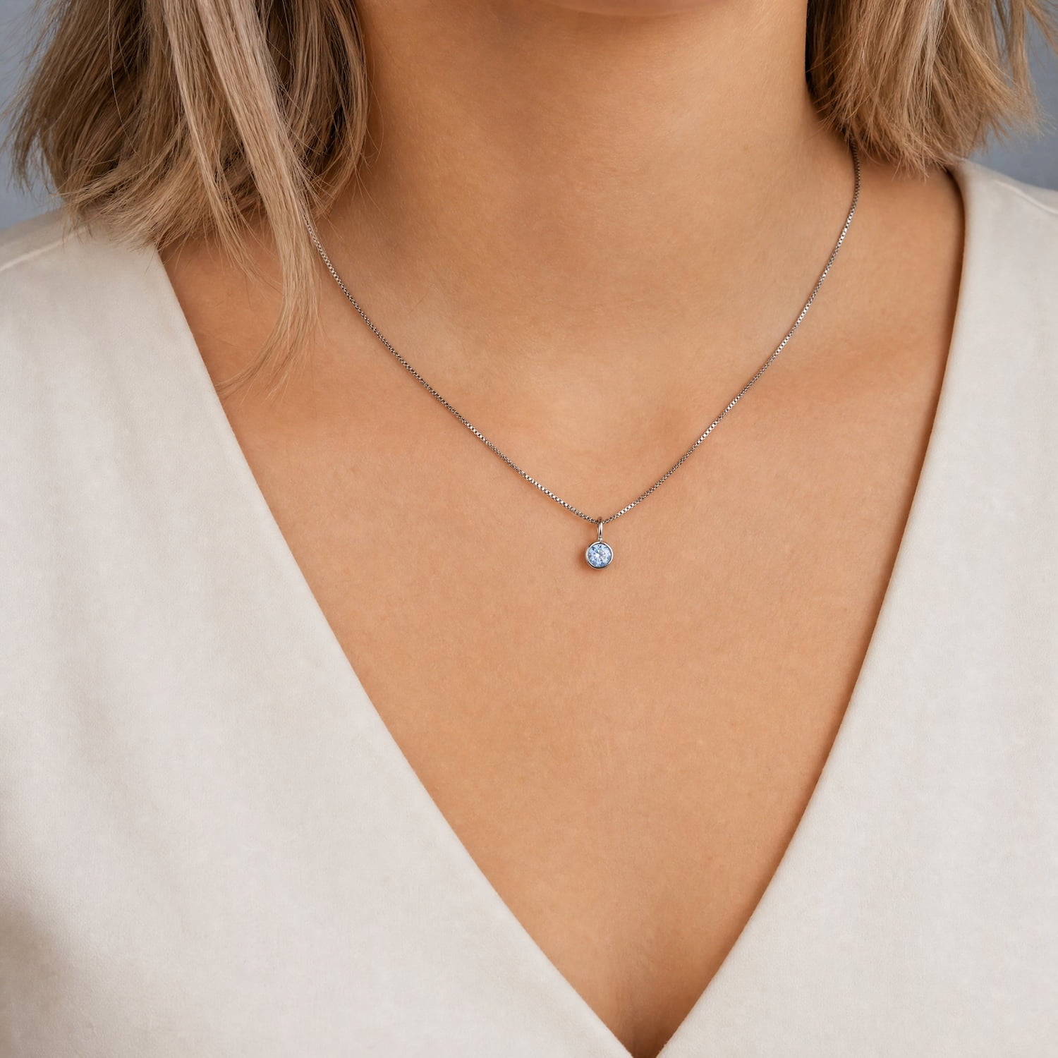 Delicate sterling silver necklace featuring a single blue topaz pendant, embodying refined craftsmanship and a subtle, elegant design.