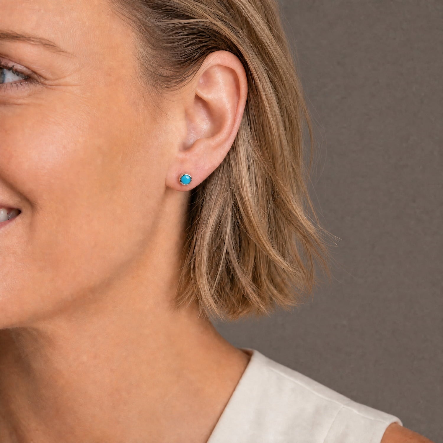 Delicate sterling silver stud earrings featuring vibrant turquoise stones, showcasing a refined, contemporary design by an award-winning British jeweller.