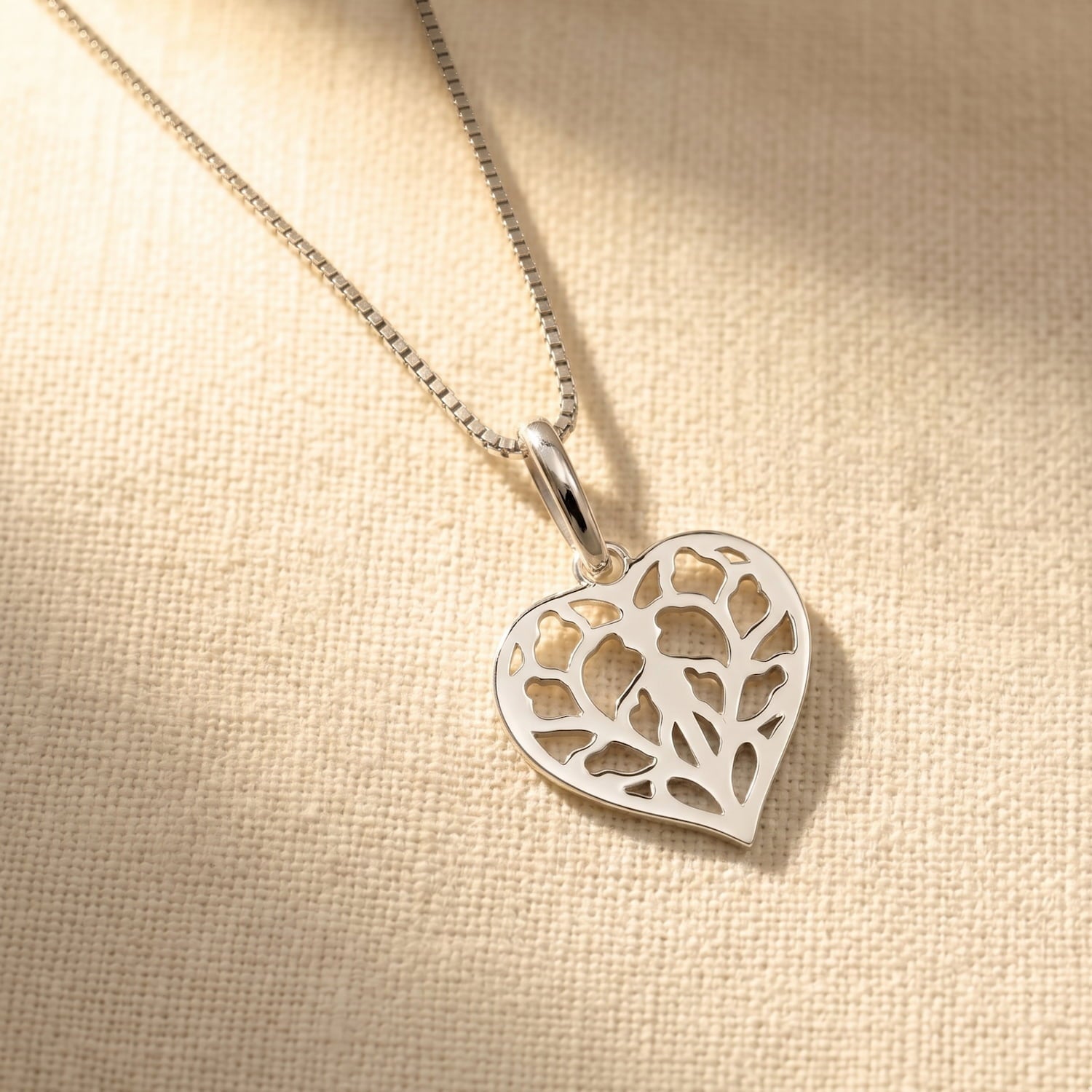 Sterling silver pendant featuring an openwork heart design inspired by Yorkshire, suspended from a fine box chain, showcasing delicate sculptural craftsmanship.