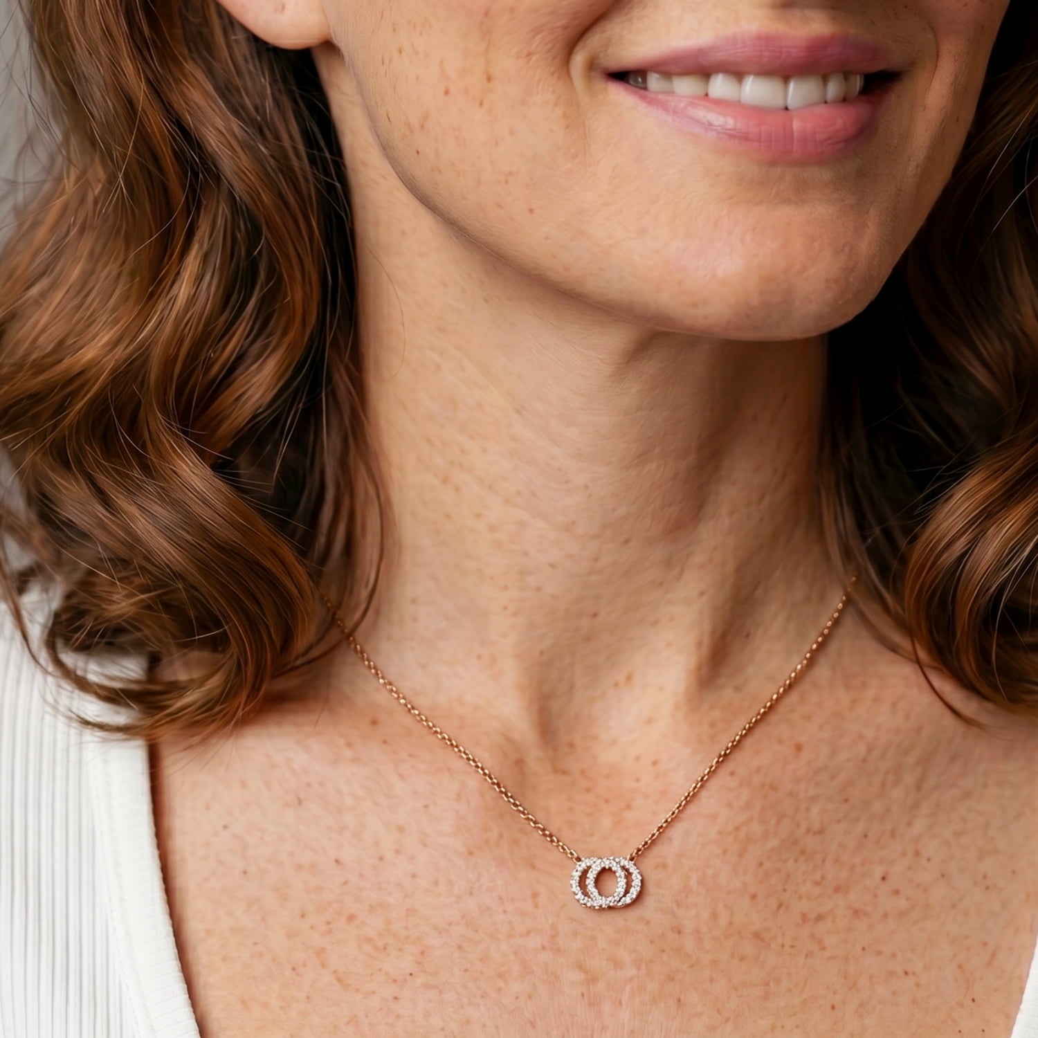 Rose gold necklace with an interlocking circular pendant.