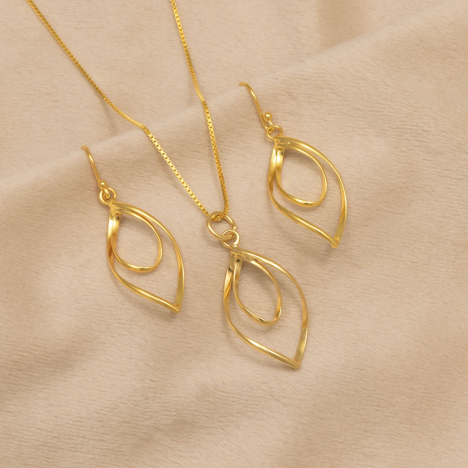 Spiral Loop Drop Earrings - Yellow Gold Vermeil with matching pendant necklace, featuring elegant intertwined loops in gold vermeil on a soft beige background.