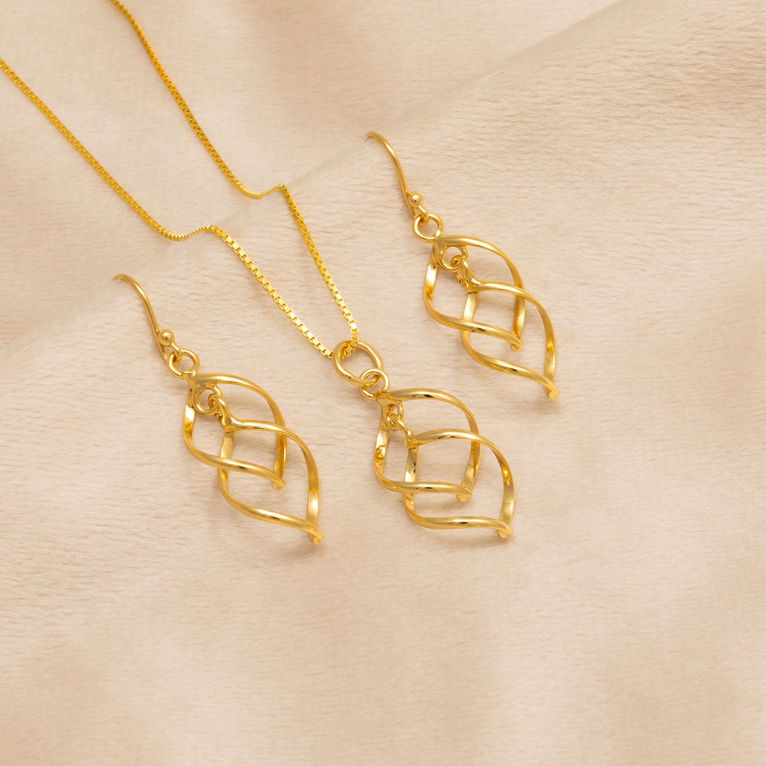 Pair of yellow gold vermeil drop earrings featuring an openwork spiral wave design, paired with a matching pendant necklace suspended from a fine chain.