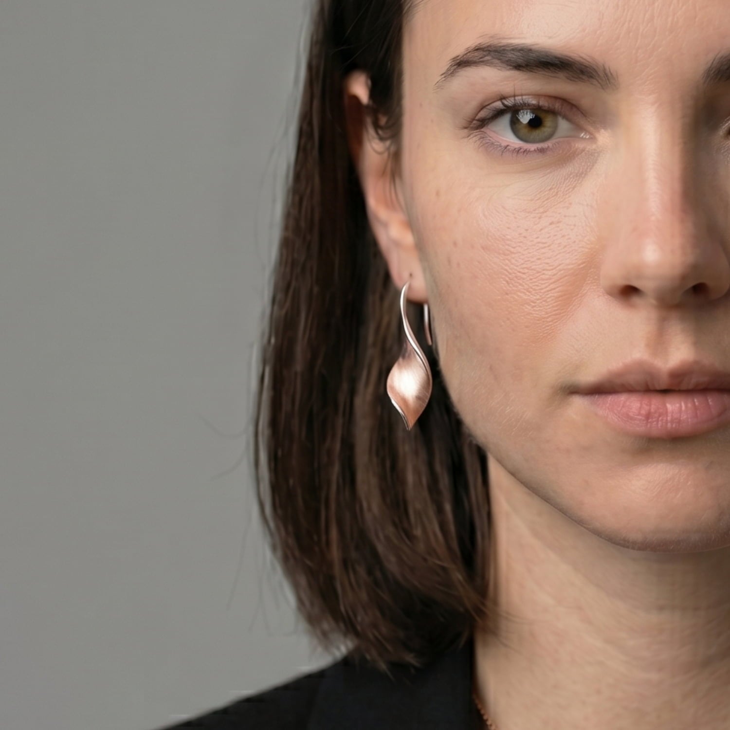 Woman wears rose gold vermeil twisting drop earrings