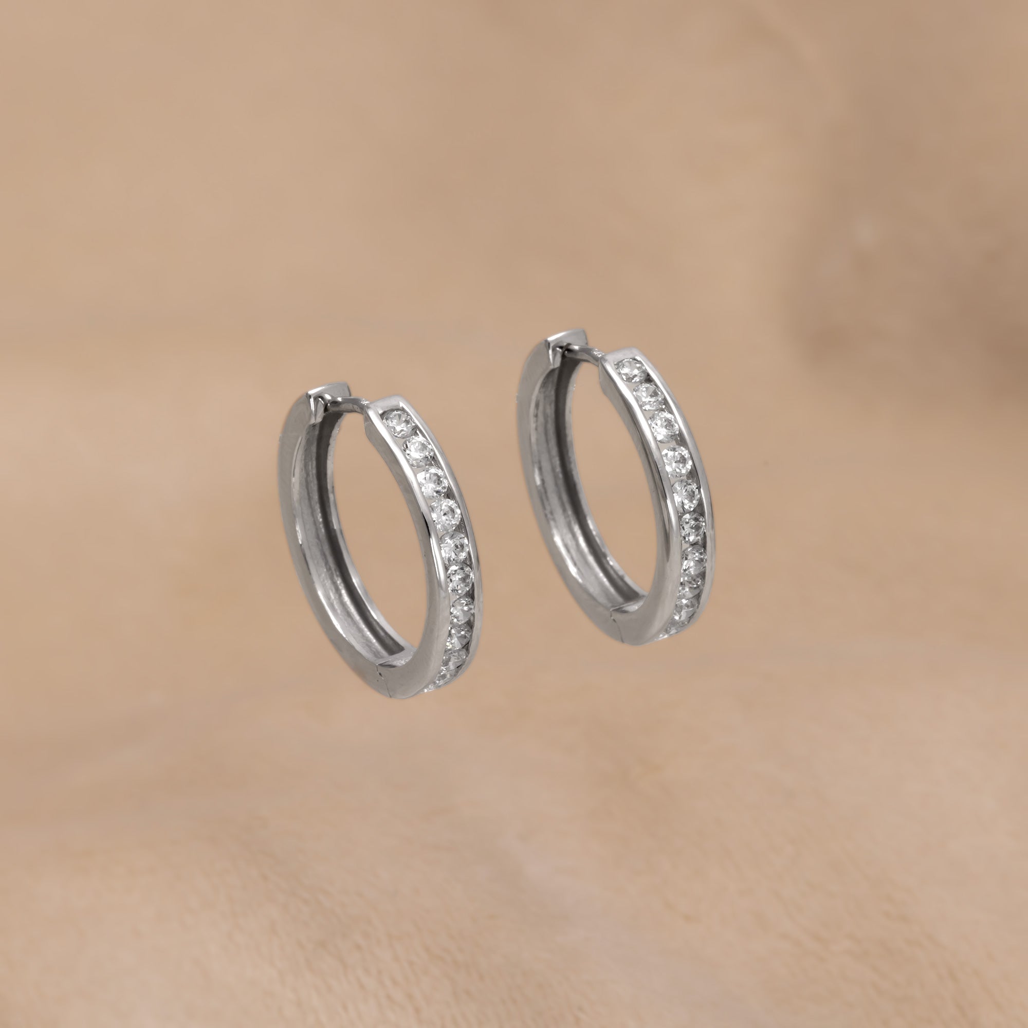 Pair of 9 carat gold hinge hoop earrings featuring a row of medium-sized stones, combining elegant design with a sculptural finish in gold vermeil jewellery.