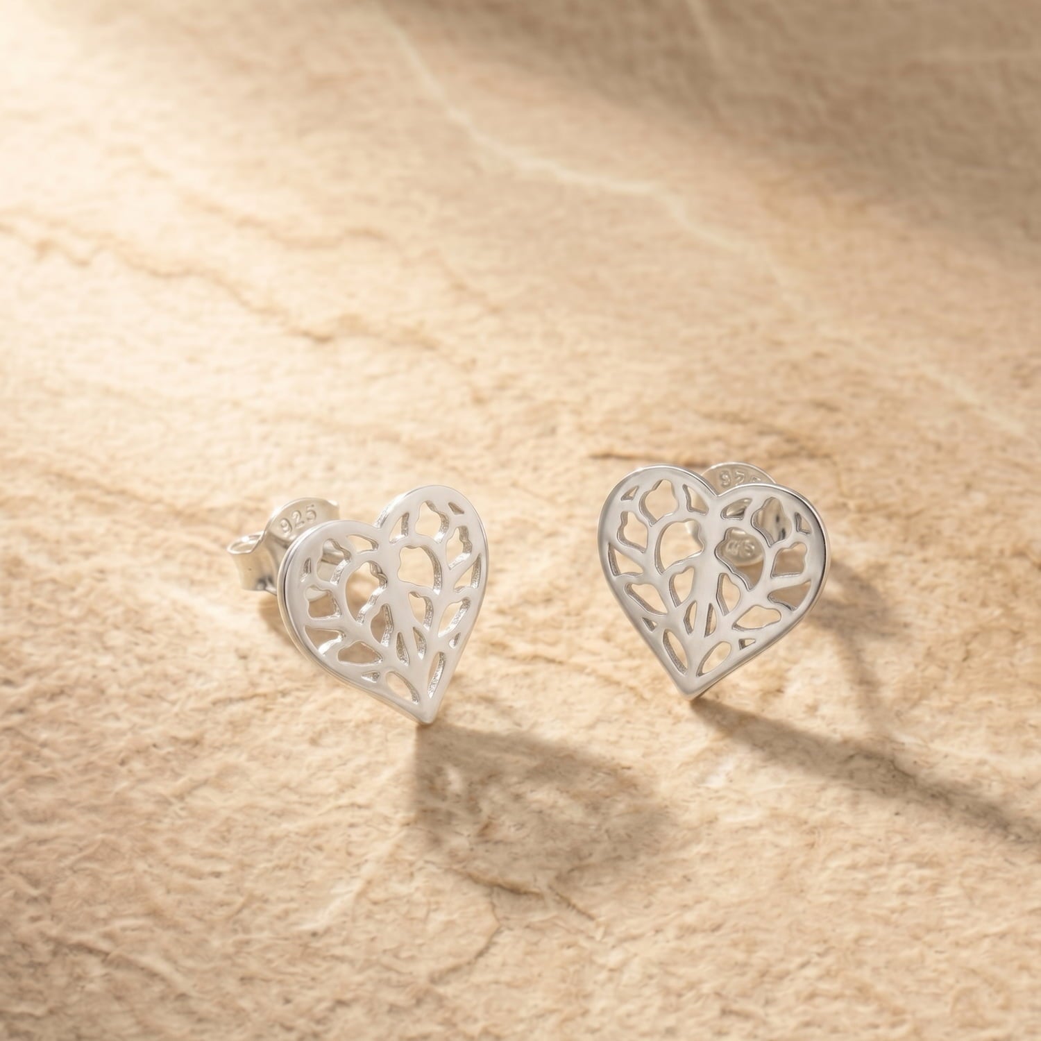 Pair of sterling silver heart-shaped stud earrings with detailed openwork inspired by Yorkshire, combining delicate craftsmanship with elegant silver jewellery design.