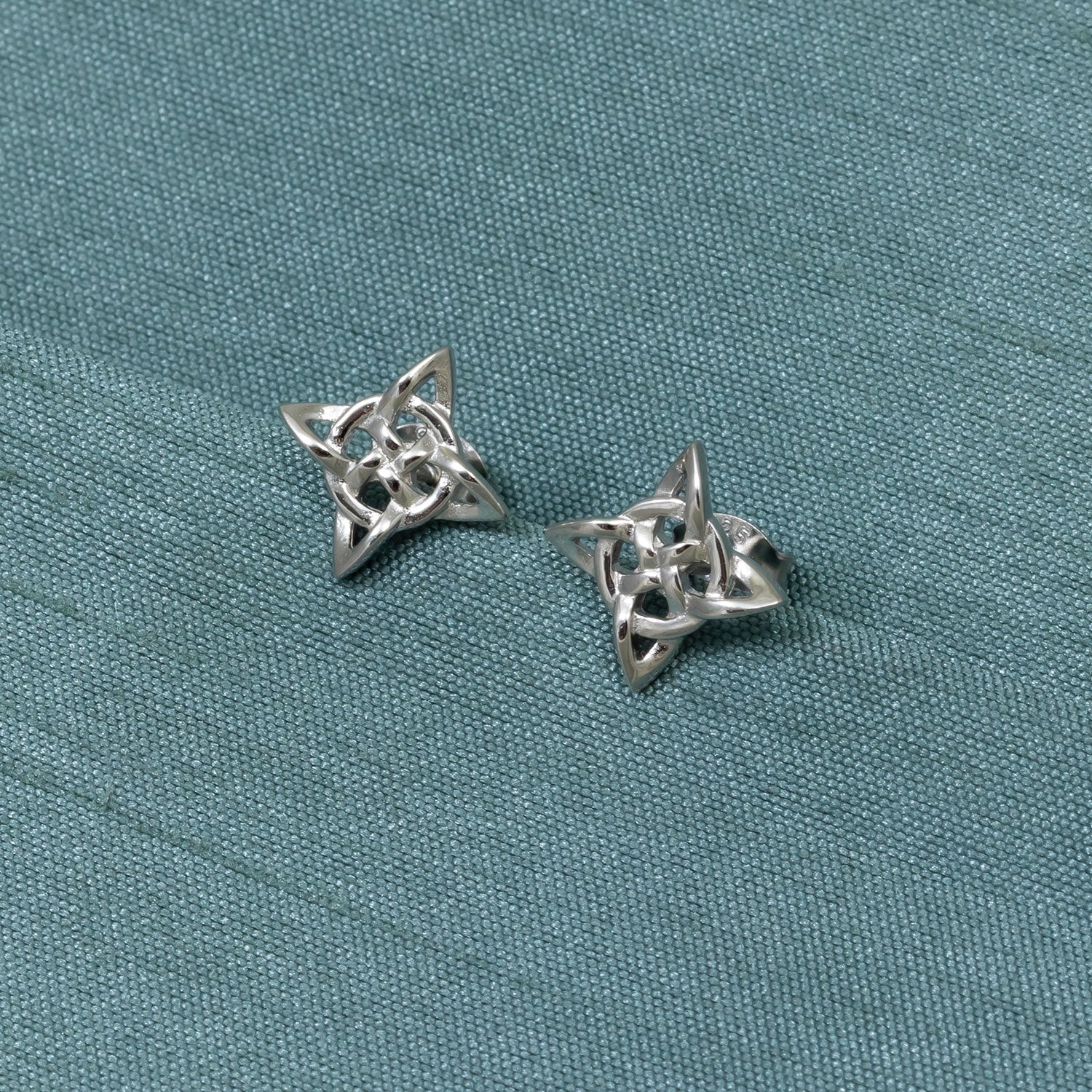 Pair of sterling silver stud earrings featuring an intricate Celtic star design with interwoven knots, embodying refined contemporary silver jewellery craftsmanship.