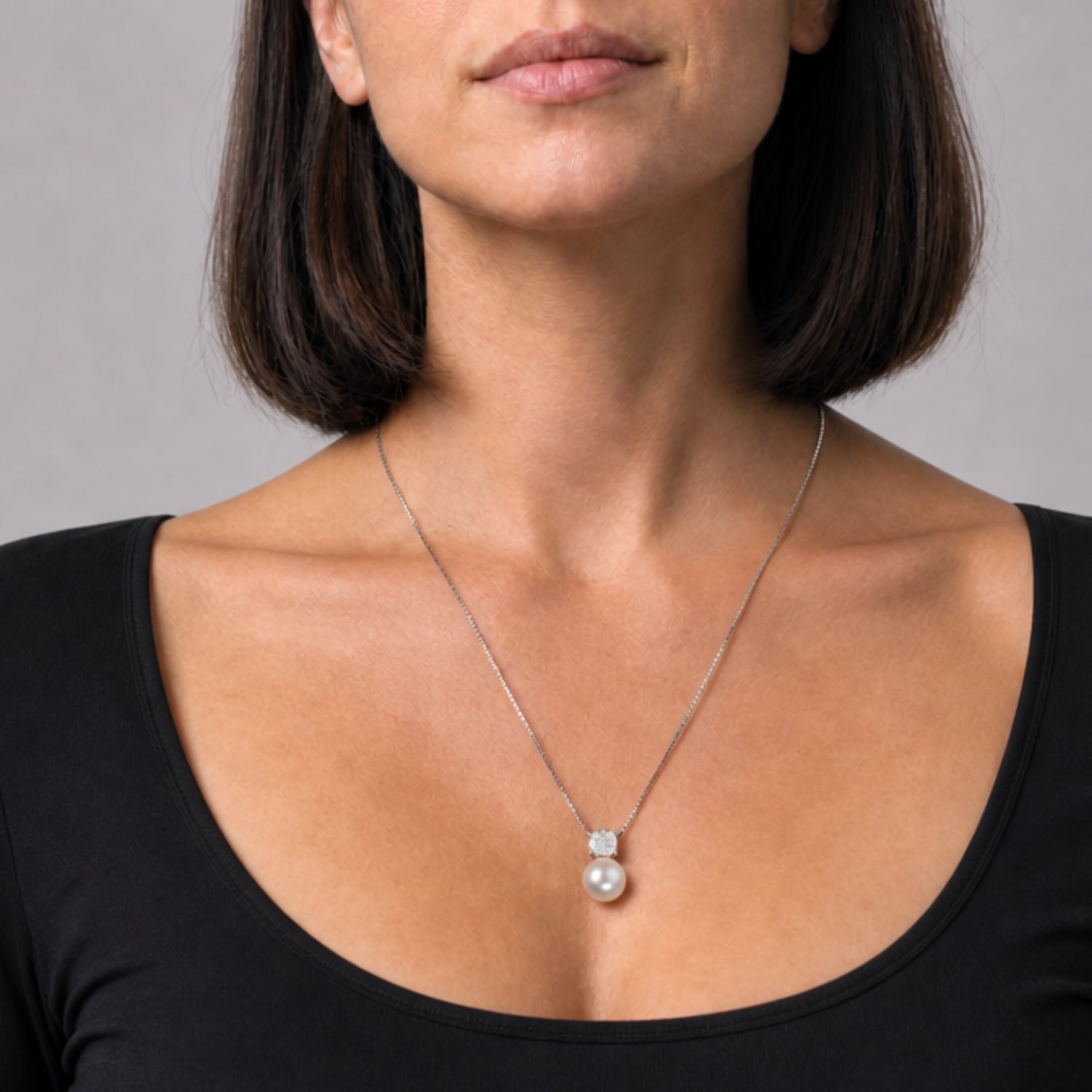 Delicate sterling silver necklace showcasing a cubist-inspired pendant with a lustrous freshwater pearl suspended from a fine chain for a modern, elegant look.