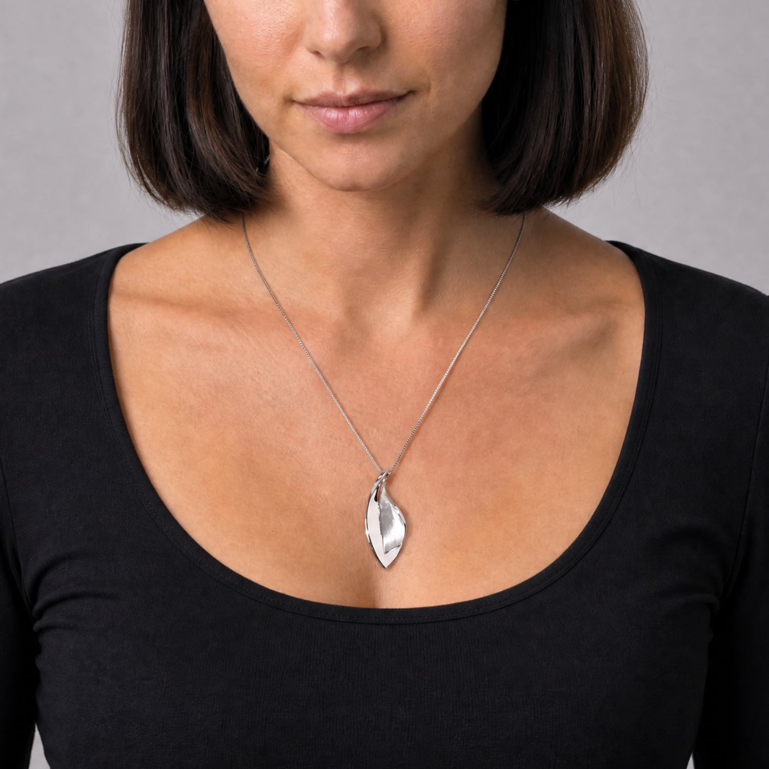 Sleek sterling silver pendant featuring a double leaf design with a smooth, polished finish, suspended from a delicate chain for refined contemporary elegance.