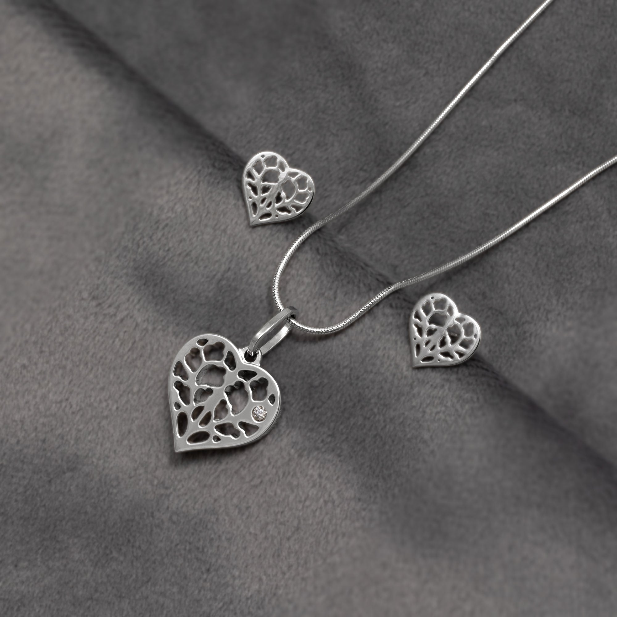 9 carat white gold heart-shaped pendant with diamond and matching stud earrings featuring delicate openwork design based on York Minster with diamond accents on a snake chain, showcasing refined contemporary craftsmanship.