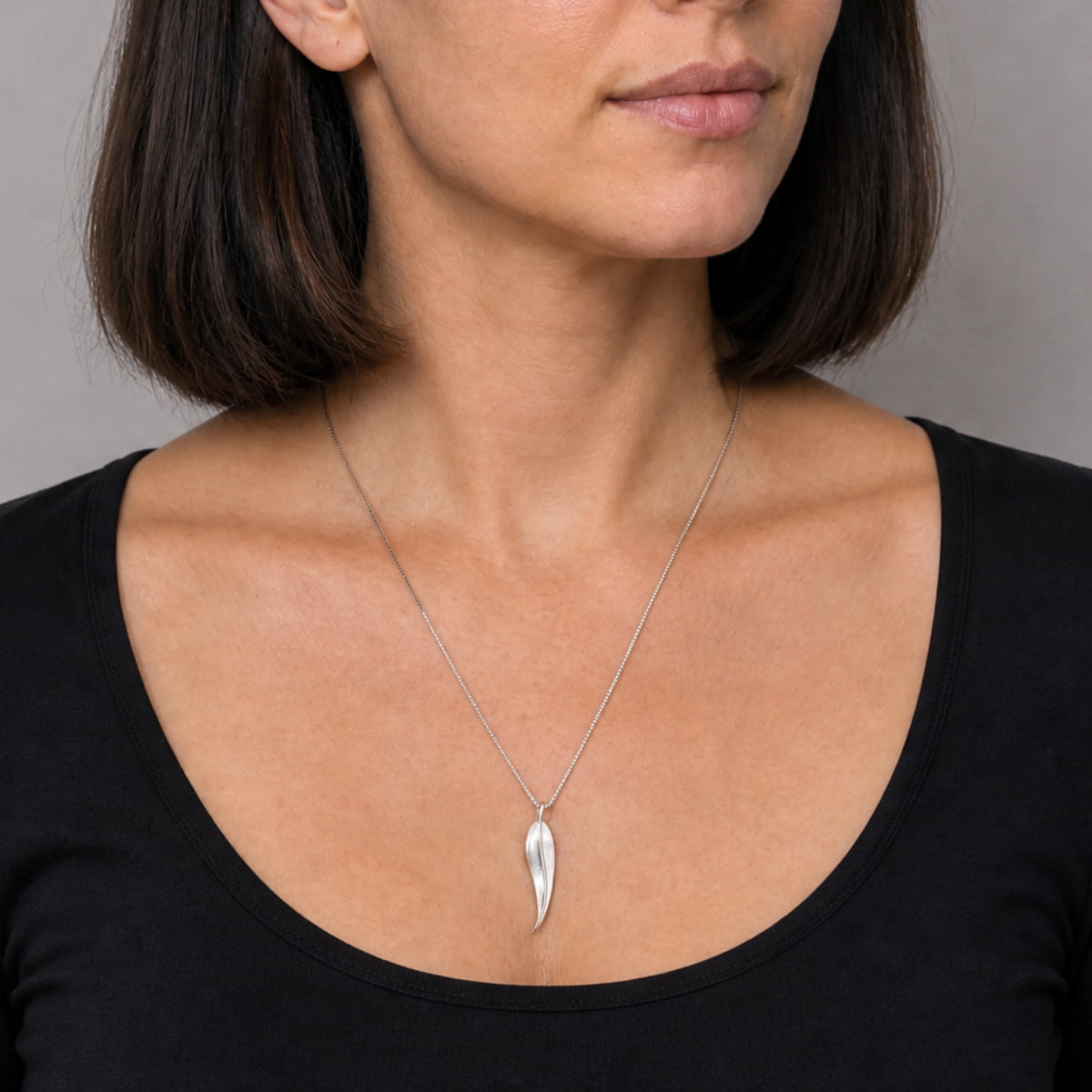 Delicate sterling silver pendant shaped as a slim leaf, suspended from a fine chain, showcasing a sleek and modern silhouette for refined everyday silver jewellery.