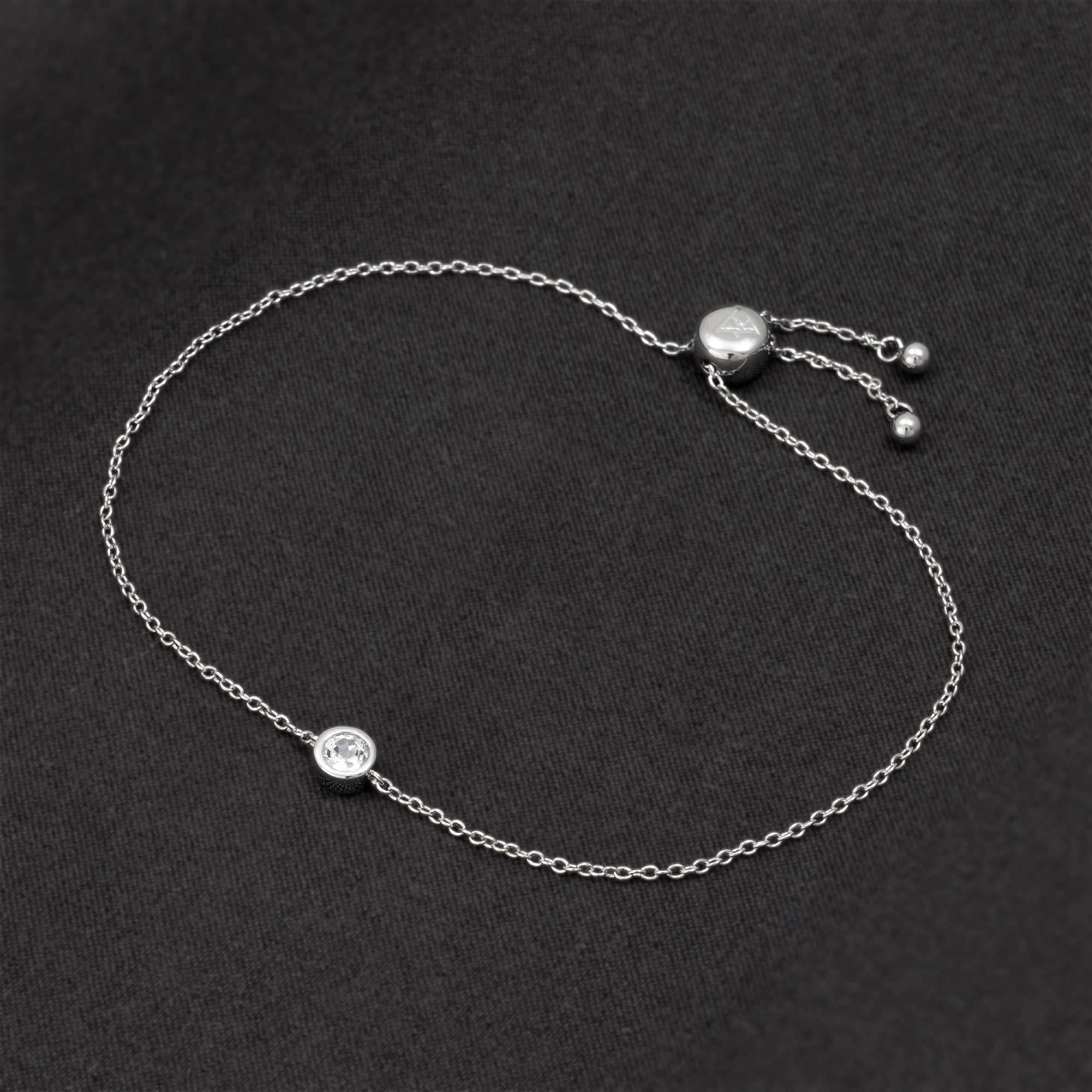 Delicate sterling silver bracelet featuring a bezel-set white topaz gemstone with an adjustable sliding clasp, combining minimalist elegance with expert British craftsmanship.