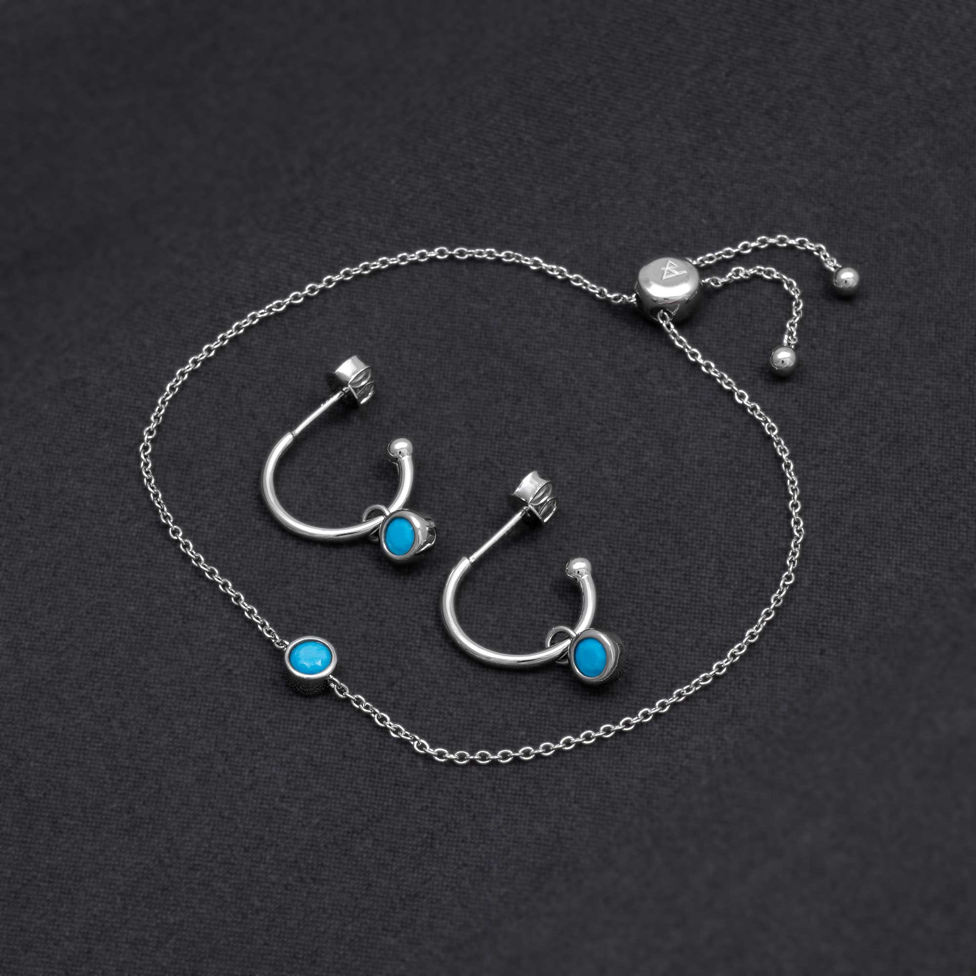 Delicate sterling silver hoop earrings and bracelet featuring vibrant turquoise stones, showcasing expertly crafted minimalist design by an award-winning British jeweller.