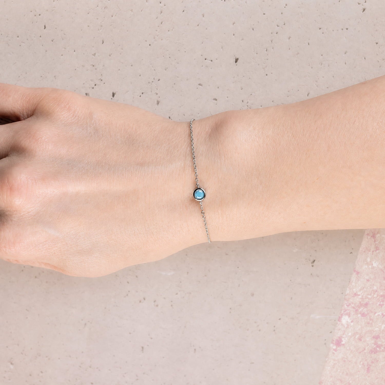 Delicate sterling silver bracelet featuring a bright turquoise birthstone with a sliding adjuster, showcasing refined craftsmanship in a minimalist design.