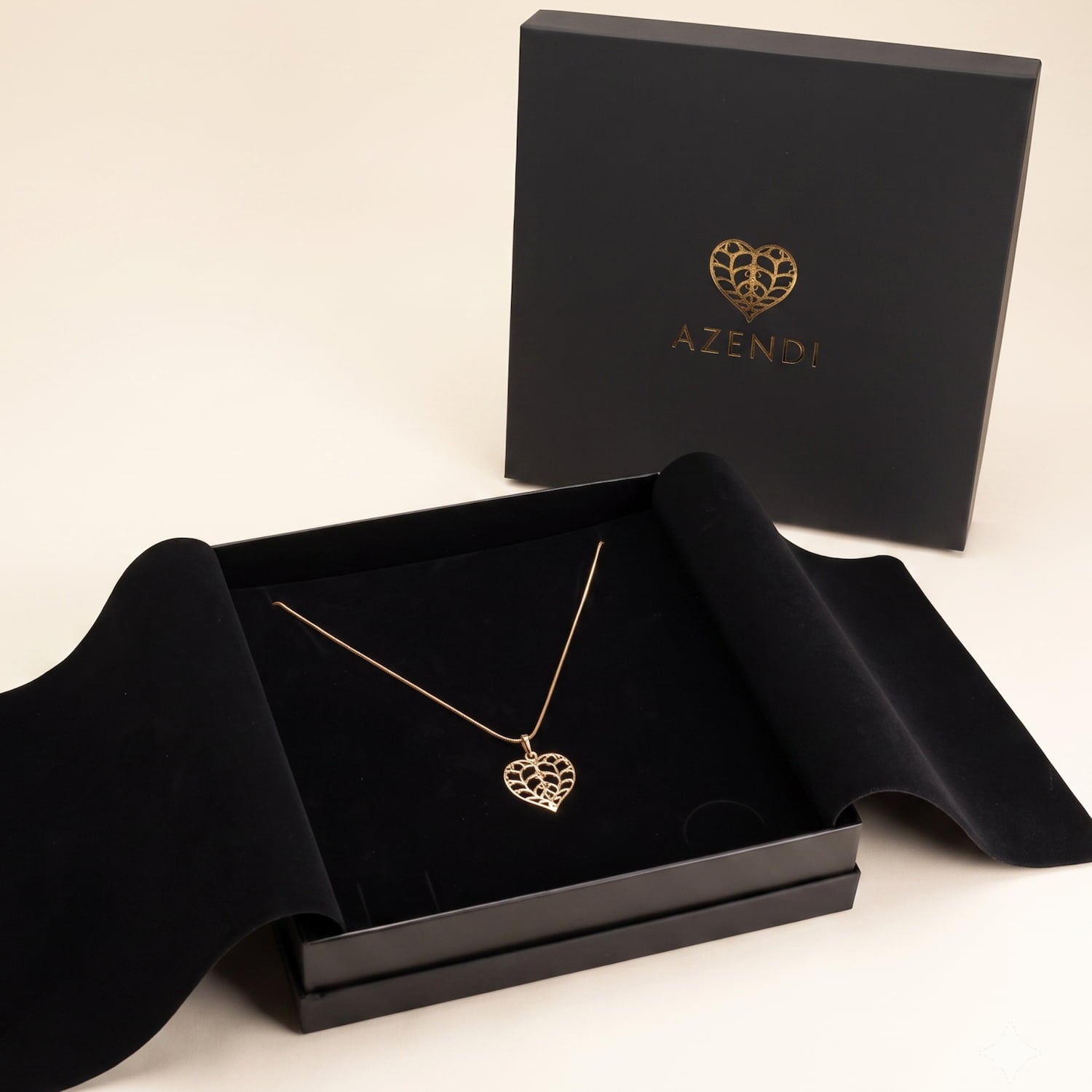 Limited edition 18ct yellow gold pendant featuring an openwork heart design, displayed on a fine chain within an elegant black presentation box by Azendi.