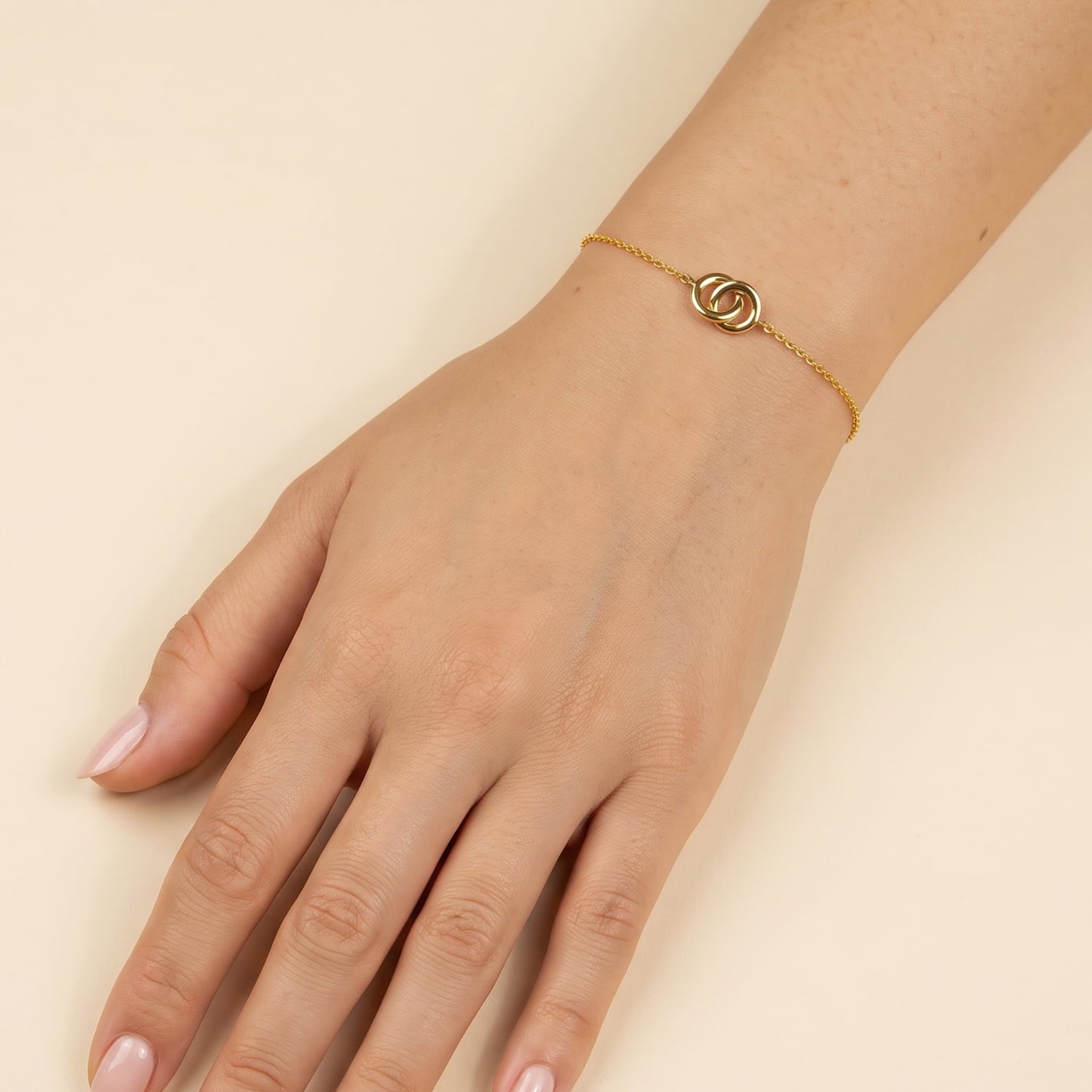 Delicate yellow gold vermeil bracelet featuring slender chain and an elegant interlocking circles motif, adjustable for a customized fit on the wrist.