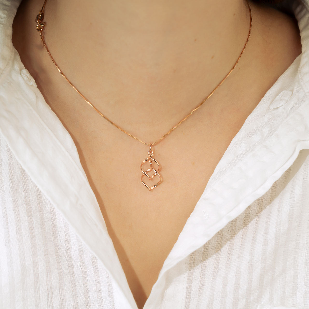 Rose gold vermeil pendant featuring a flowing spiral wave design suspended from a fine chain, exemplifying contemporary sculptural elegance in gold vermeil jewellery.