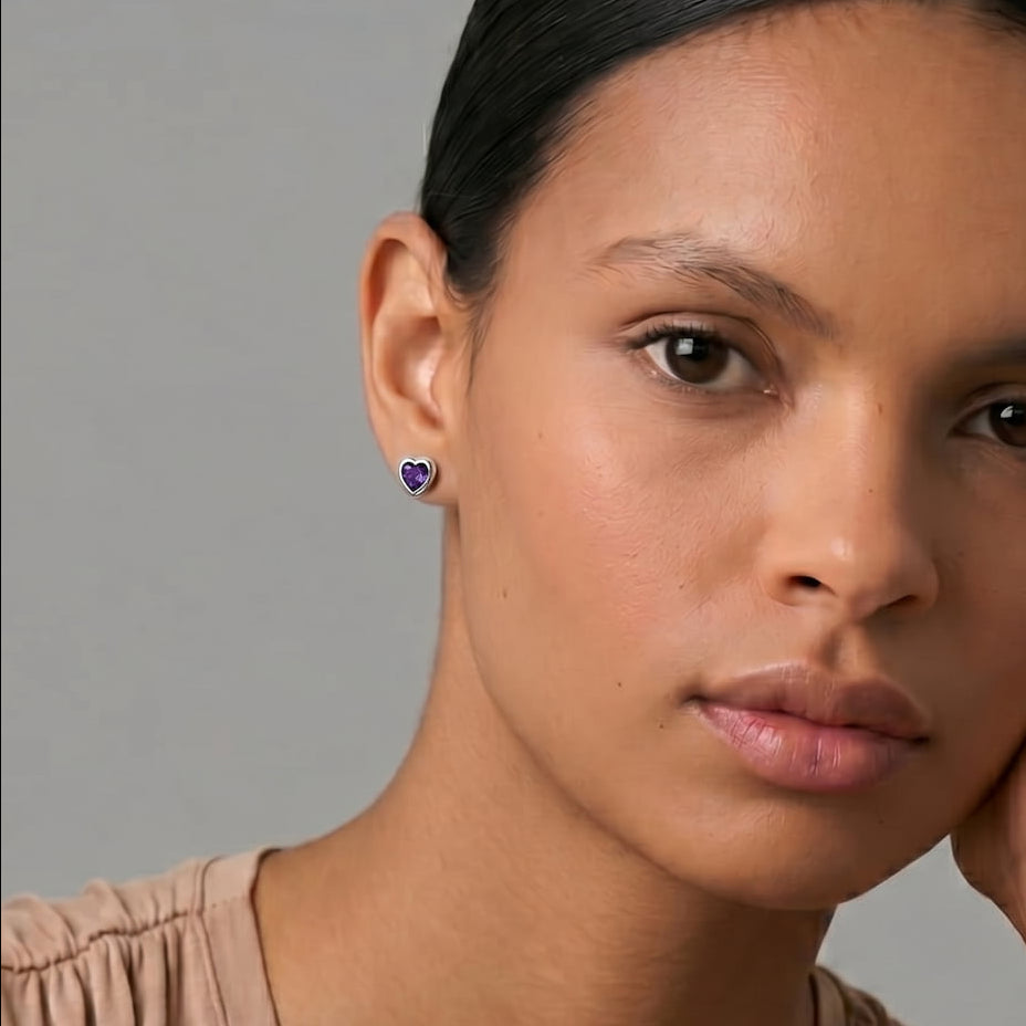 Woman wears amethyst heart shaped silbver stud earrings