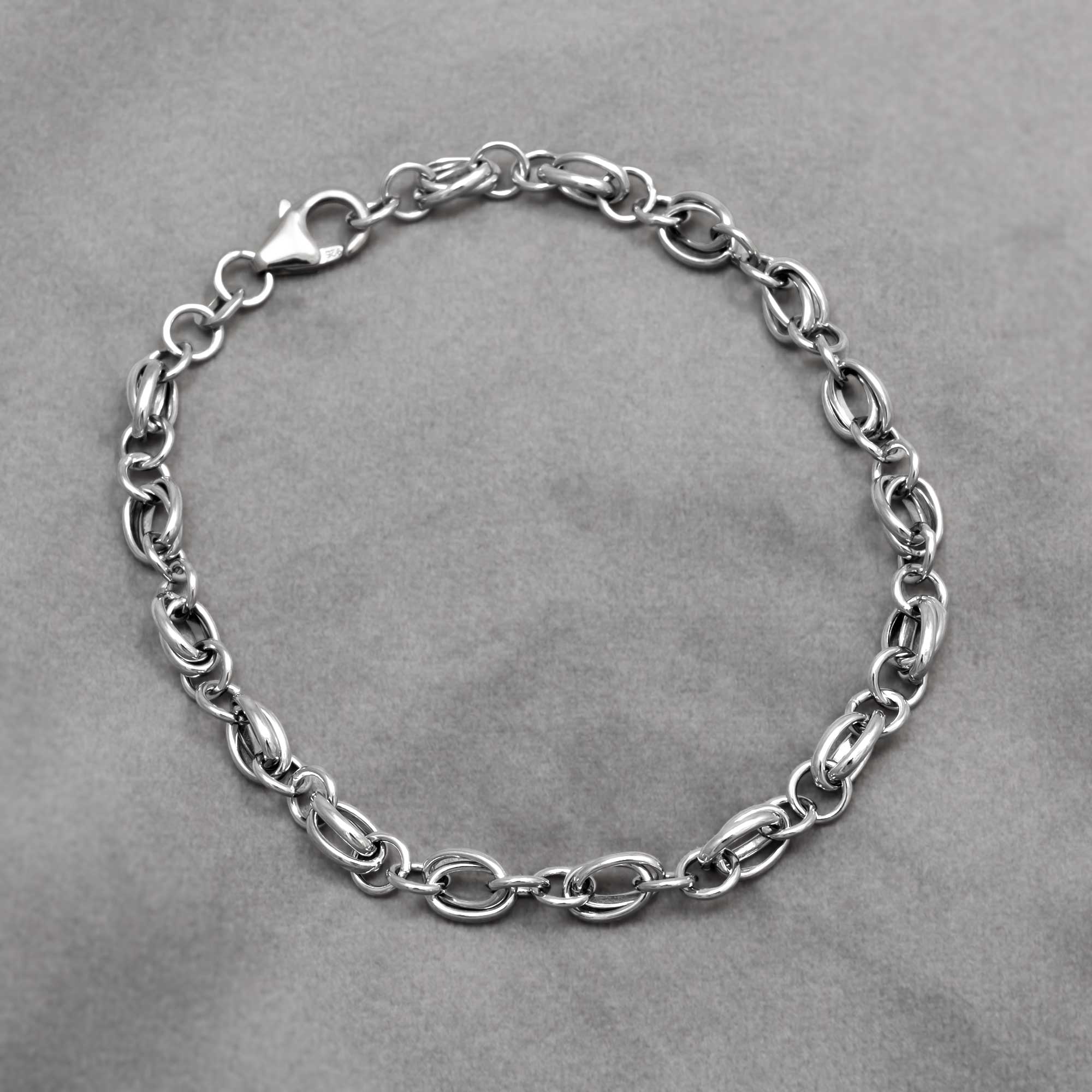 Sterling silver double twisted oval links chain bracelet on a grey background
