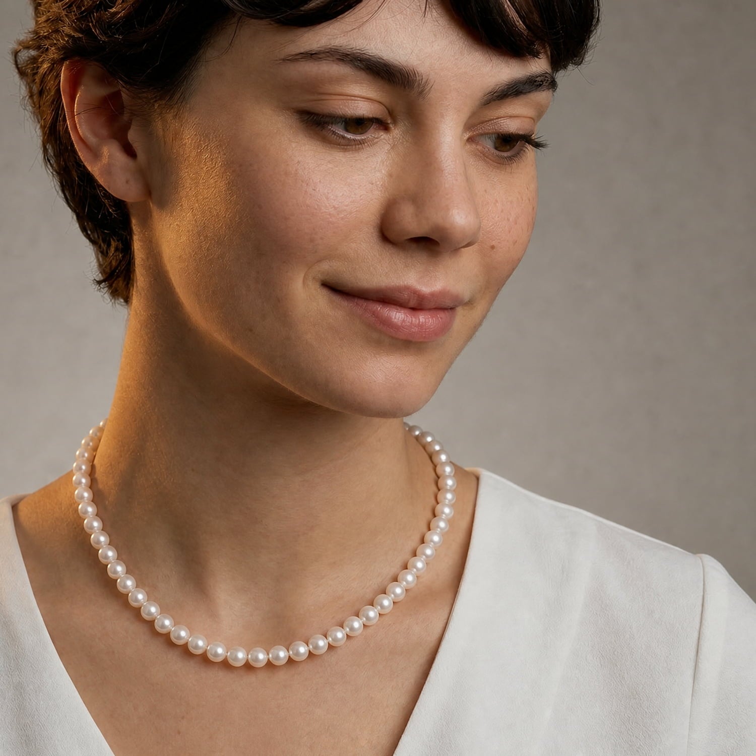 Model wears shorter length classic pearl necklace
