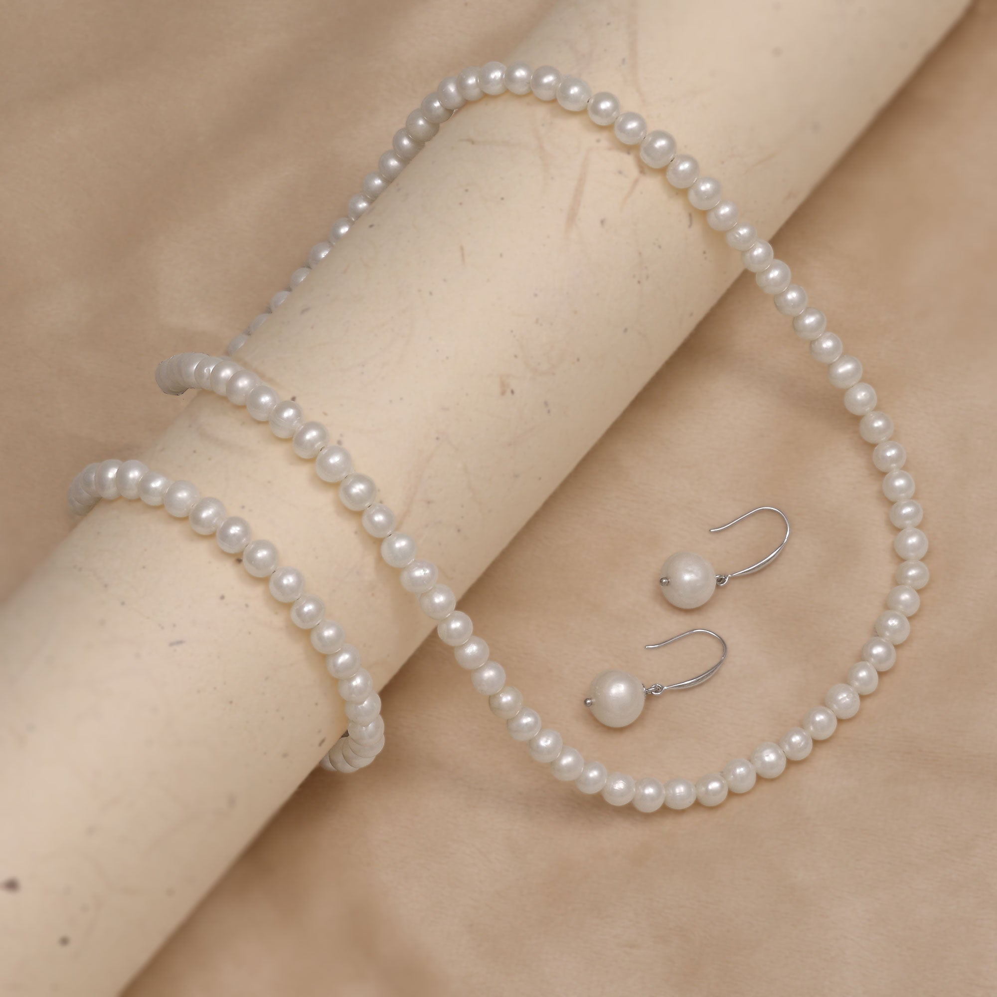 A classic string of white freshwater pearls with matching bracelet and drop earrings