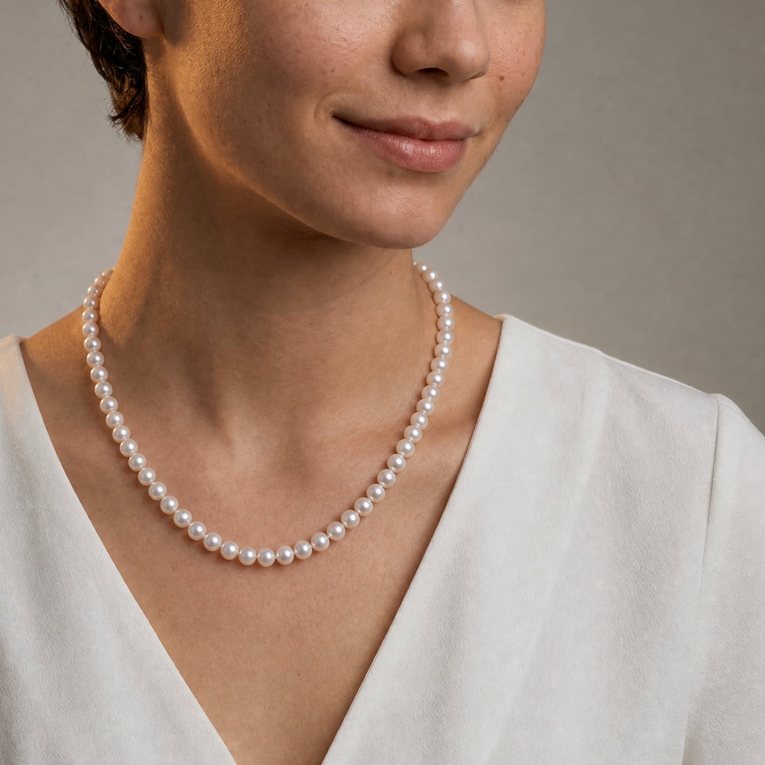 Model wears a classic string of white freshwater pearls