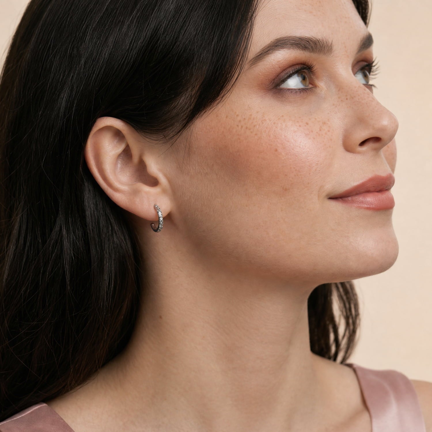 A model wears silver textured hoop earrings