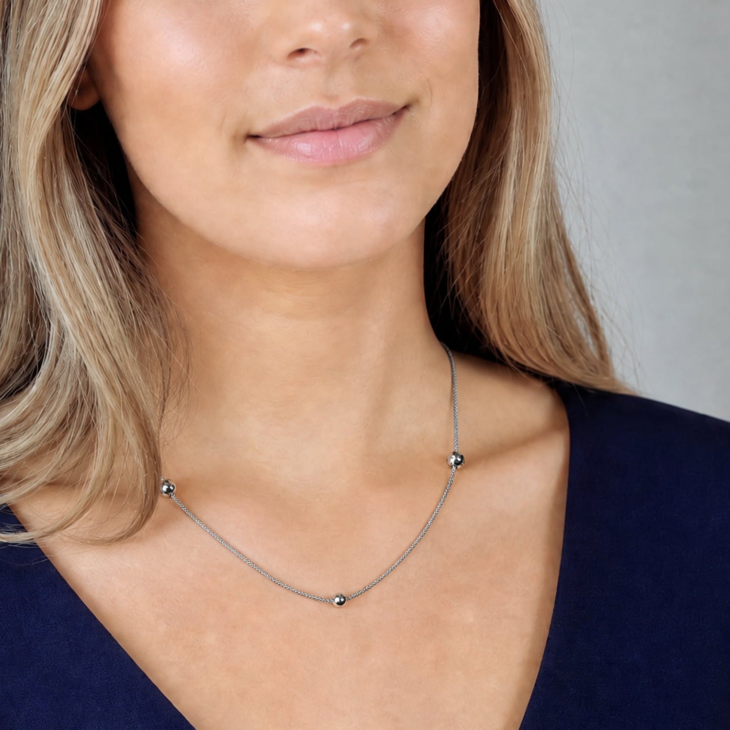 Sterling silver popcorn chain necklace with textured beads worn with a navy dress