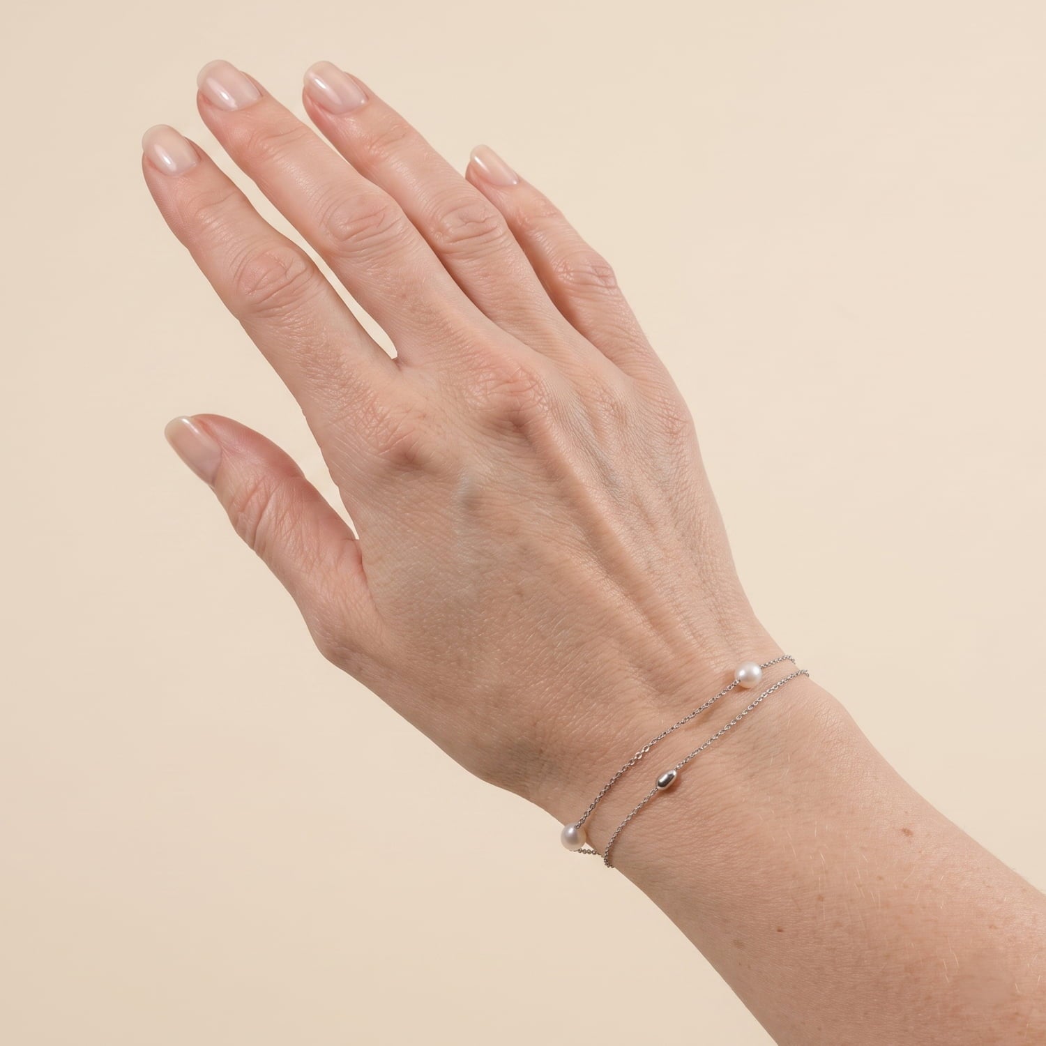 Silver bracelet with chain, silver beads and freshwater pearls shown on a wrist