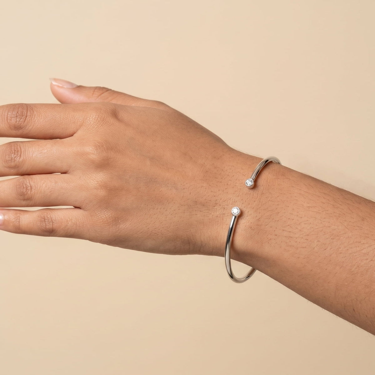 Model wears a silver bangle with lab grown diamonds.