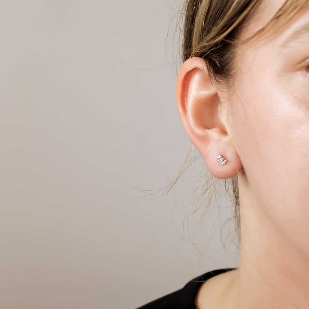 Delicate sterling silver stud earrings featuring a triple cubic zirconia cluster, designed for a subtle yet sparkling finish with refined contemporary elegance.