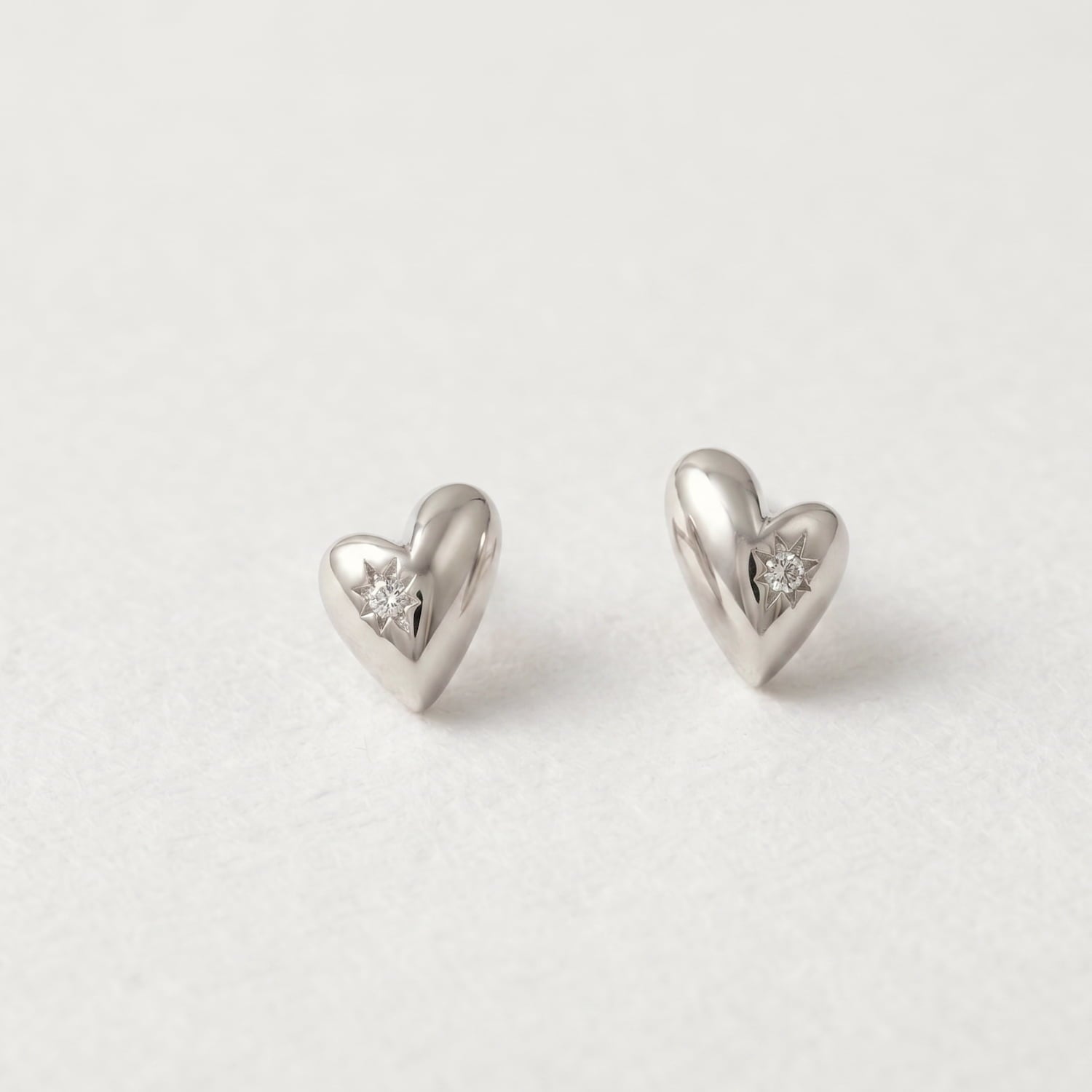 Heart-shaped silver earrings with embedded cubic zirconia