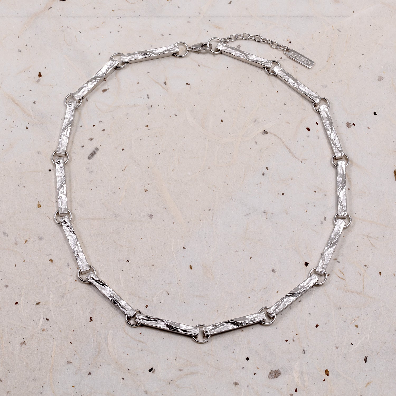 Sterling silver link necklace featuring elongated, textured bar-shaped links connected by small round rings, finished with an adjustable extension chain for versatile wear.