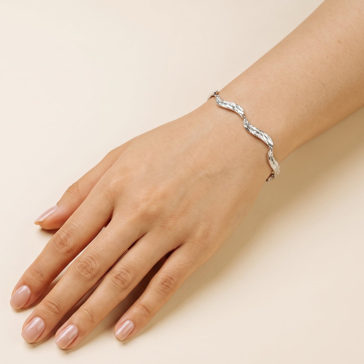 Sterling silver bracelet featuring sculptural, textured links inspired by flowing water, offering a sleek and contemporary design in fine silver jewellery.