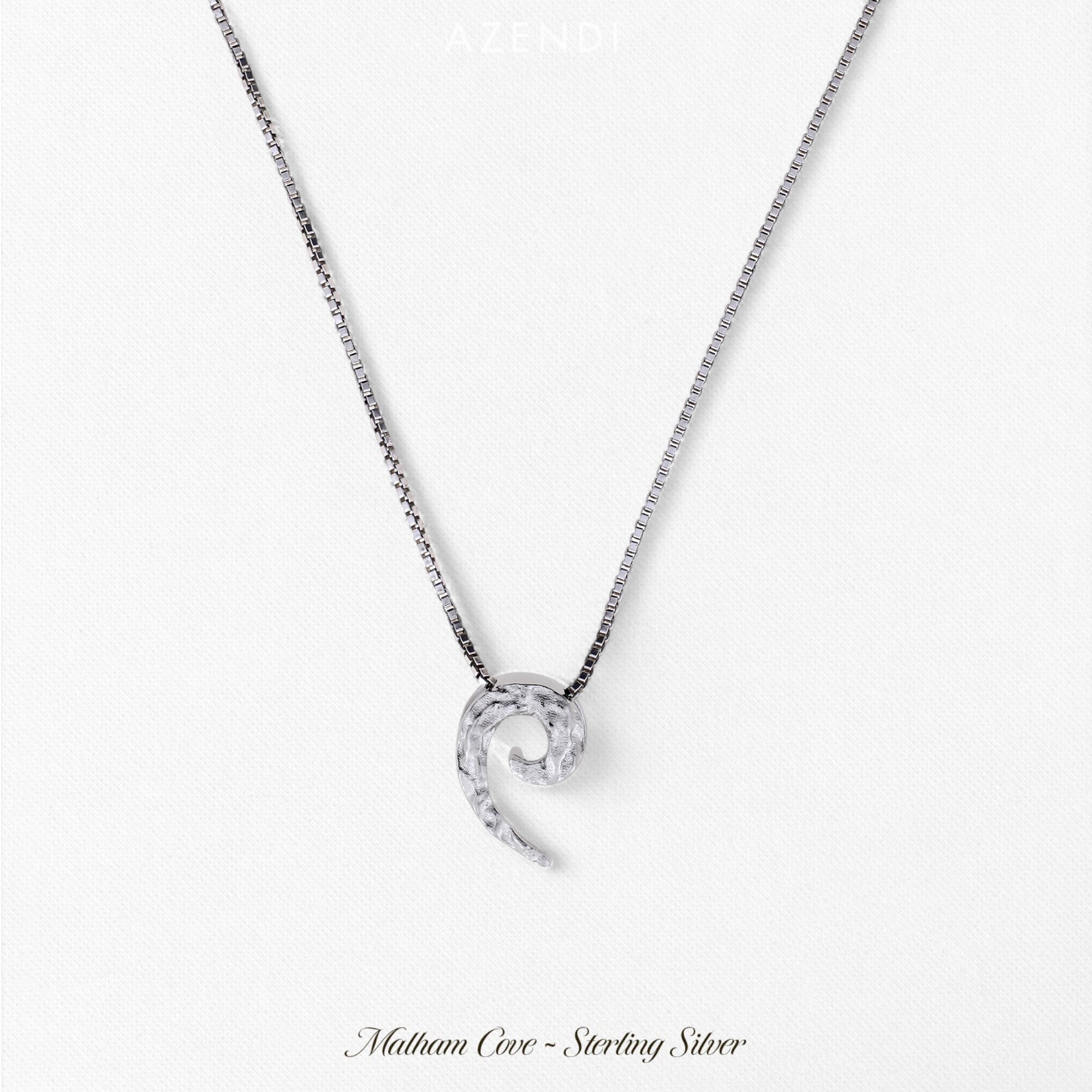 Sterling silver pendant inspired by natural curling shapes, featuring a textured surface suspended from a sleek, polished silver chain for contemporary British silver jewellery.