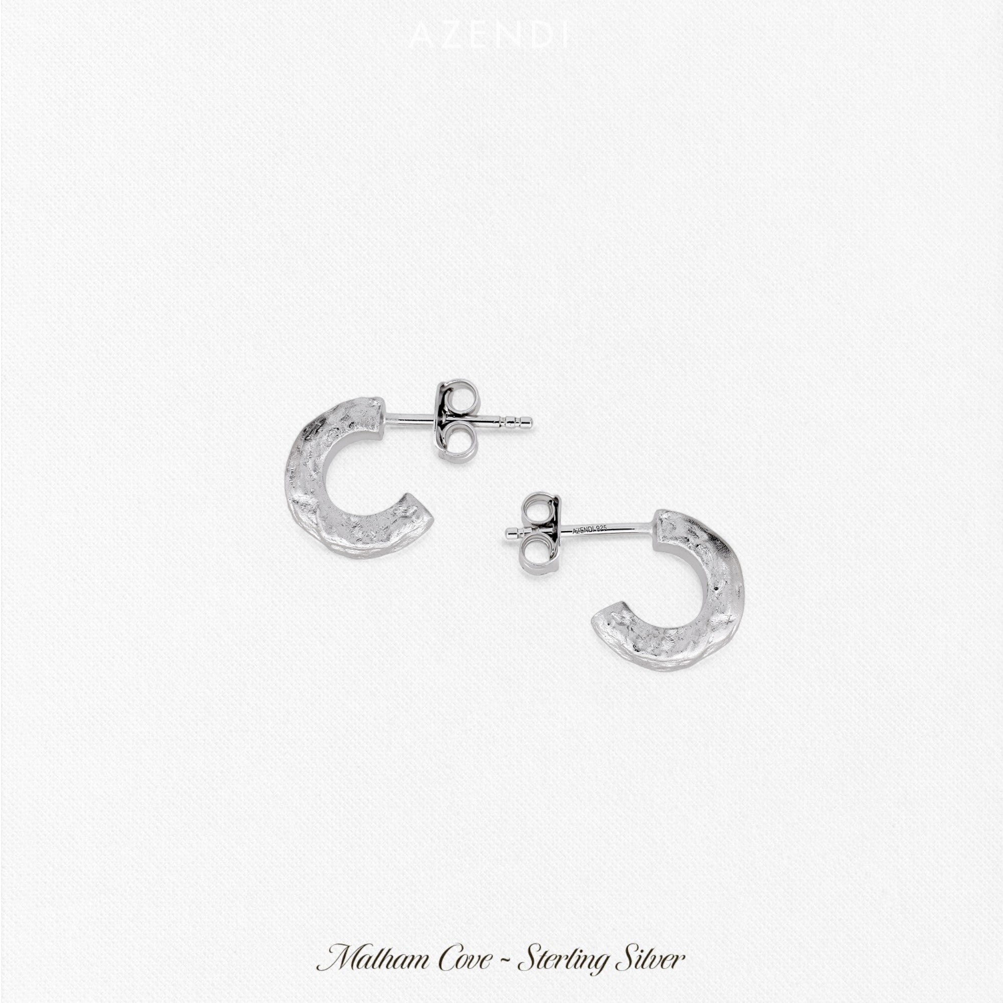 Pair of textured half hoop earrings in polished sterling silver, featuring a sculptural hammered surface that adds depth and contemporary elegance to fine silver jewellery.