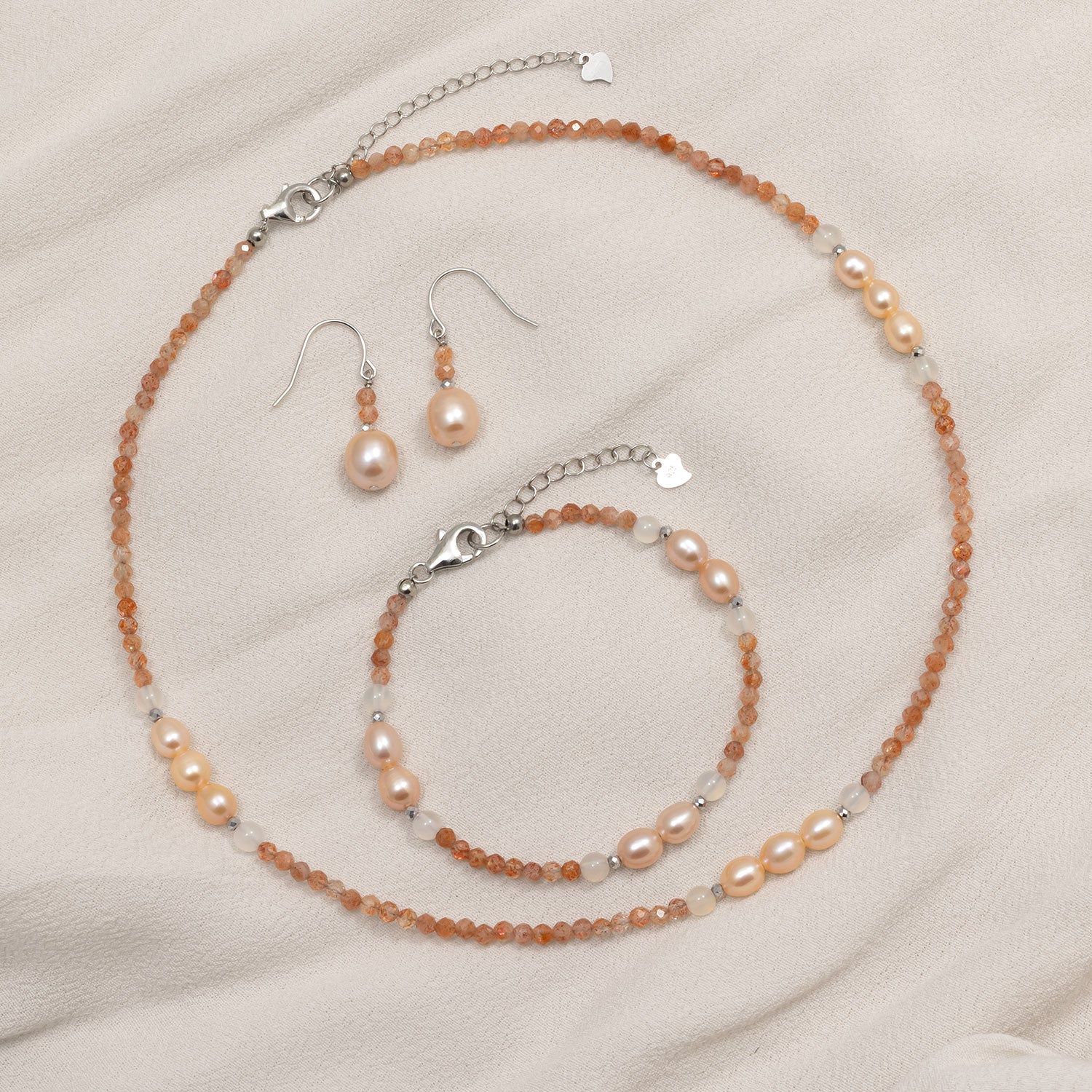 Delicate sterling silver earrings featuring warm sunstone beads paired with luminous freshwater pearls, creating a balanced and elegant design in fine silver jewellery.