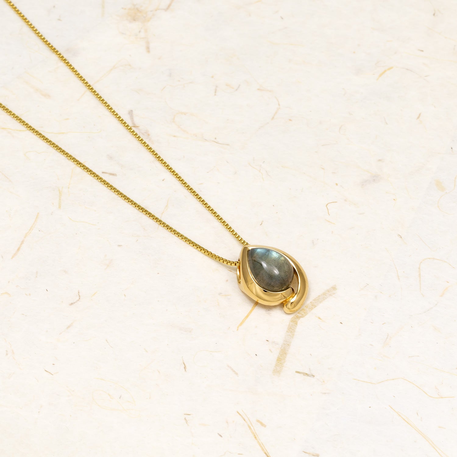 Delicate gold vermeil necklace featuring a polished teardrop spectrolite stone set in a smooth contemporary bezel, showcasing elegant and sculptural designer jewellery.