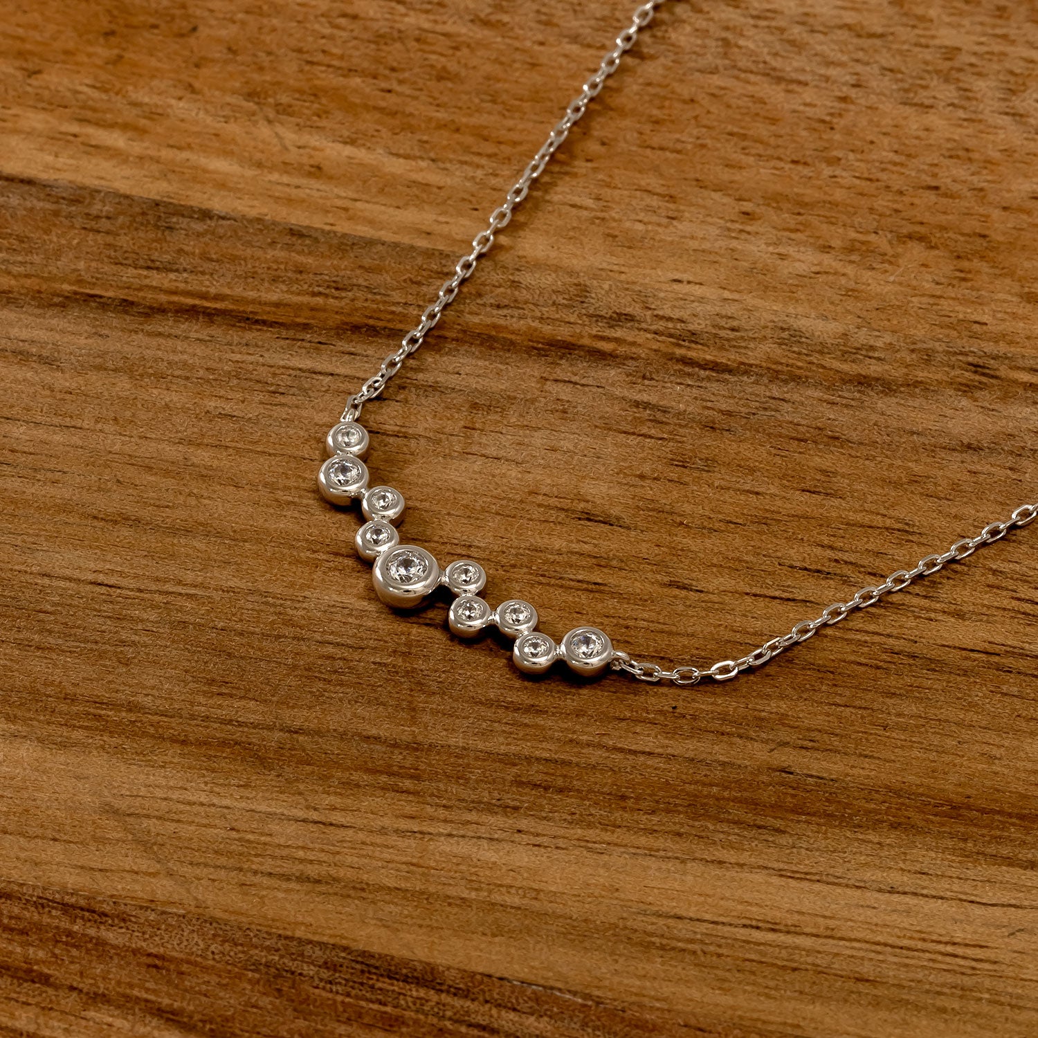 Sterling silver necklace featuring a graceful cluster of sparkling cubic zirconia stones arranged on a fine chain, embodying contemporary British jewellery design.