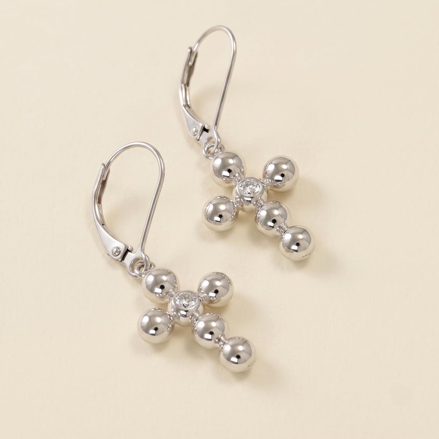 Pair of sterling silver drop earrings featuring beaded cross designs accented with sparkling cubic zirconia stones, combining sculptural elegance with refined British craftsmanship.