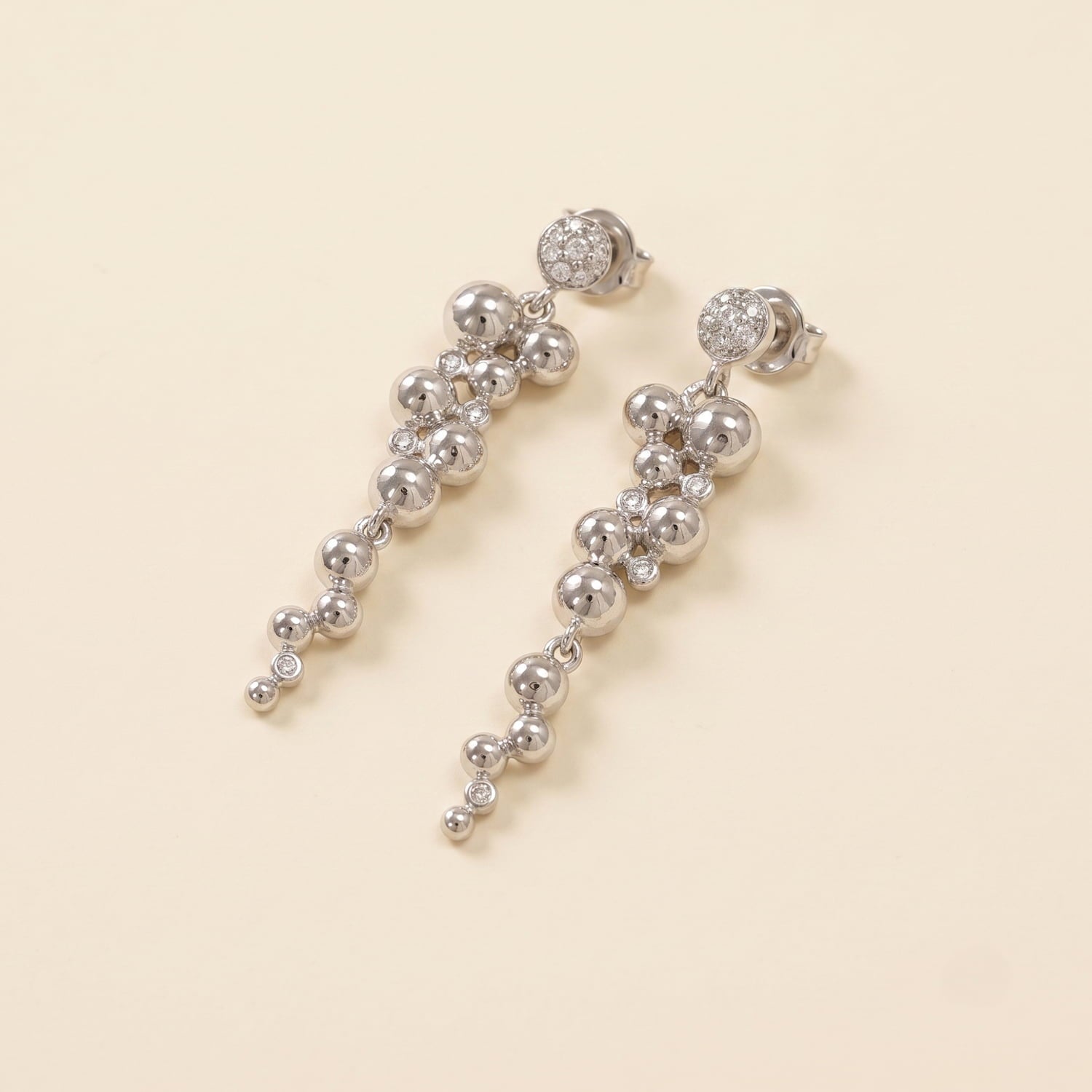 Pair of sterling silver drop earrings featuring a cascading bead design accented with sparkling cubic zirconia stones, embodying refined British craftsmanship.