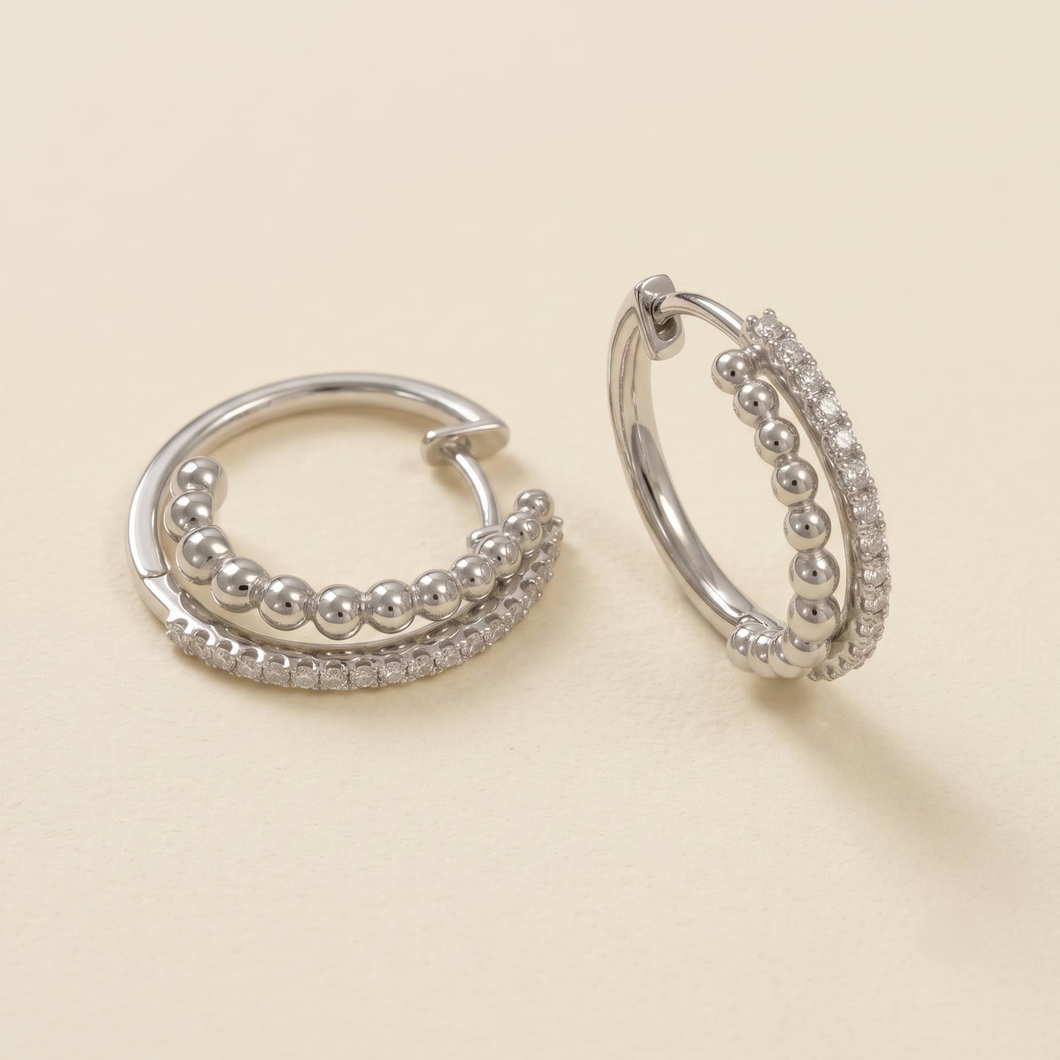 Pair of silver double hoop earrings featuring polished beads and sparkling cubic zirconia.