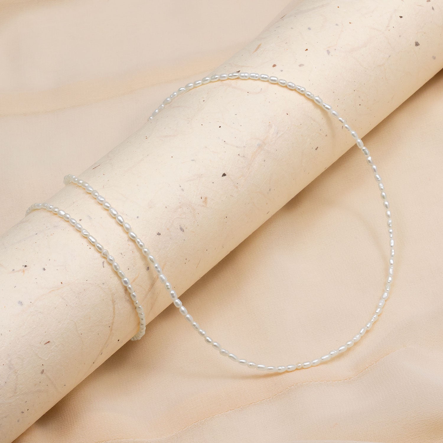 Delicate sterling silver bracelet featuring a string of lustrous freshwater seed pearls, showcasing refined elegance and subtle texture in fine designer jewellery.