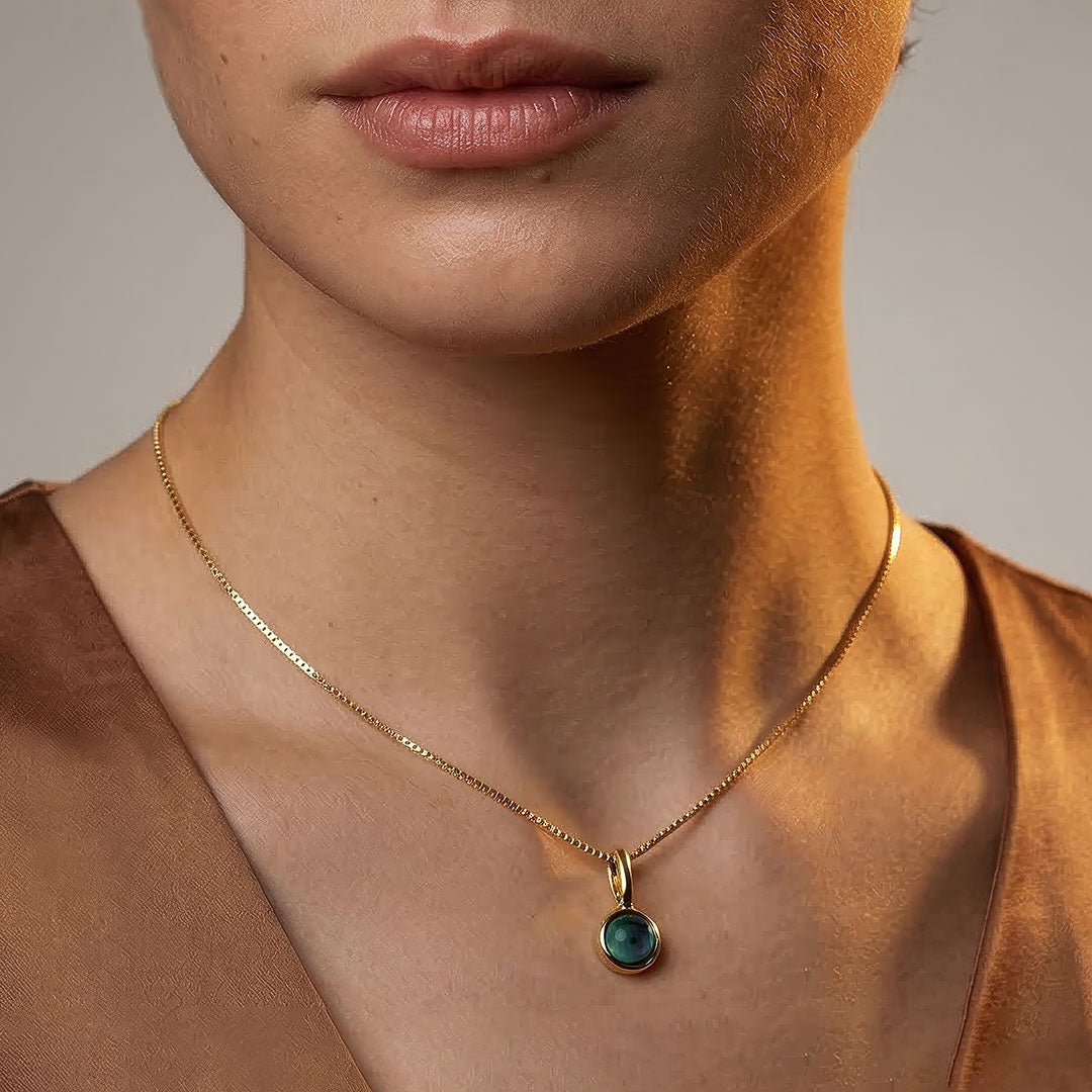 Delicate gold vermeil pendant showcasing a round malachite stone, suspended from a fine chain and worn as an elegant necklace for refined everyday styling.