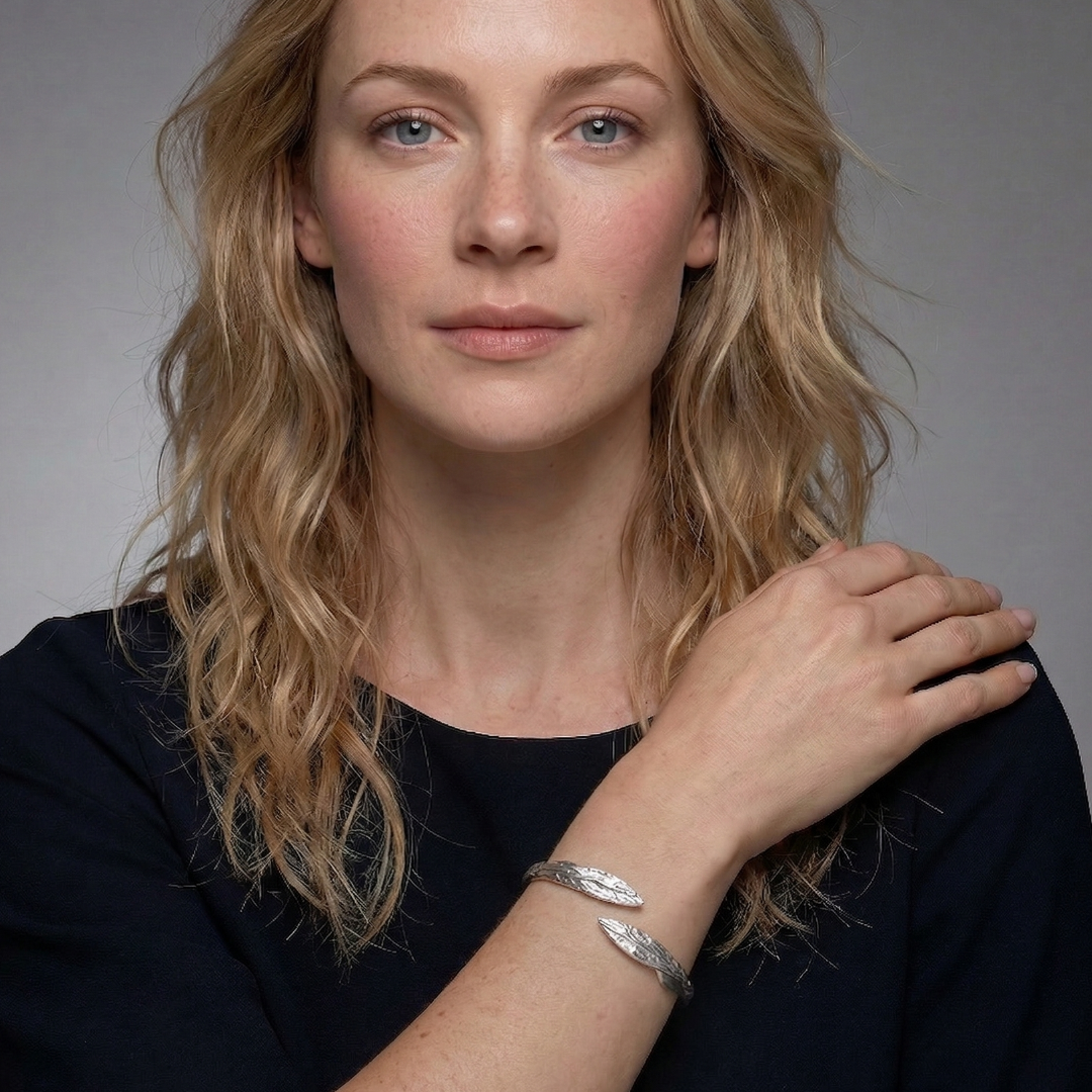 Sterling silver hinged bangle with a sculptural curved design featuring contrasting polished and textured leaf-shaped elements, embodying modern elegance in silver jewellery.