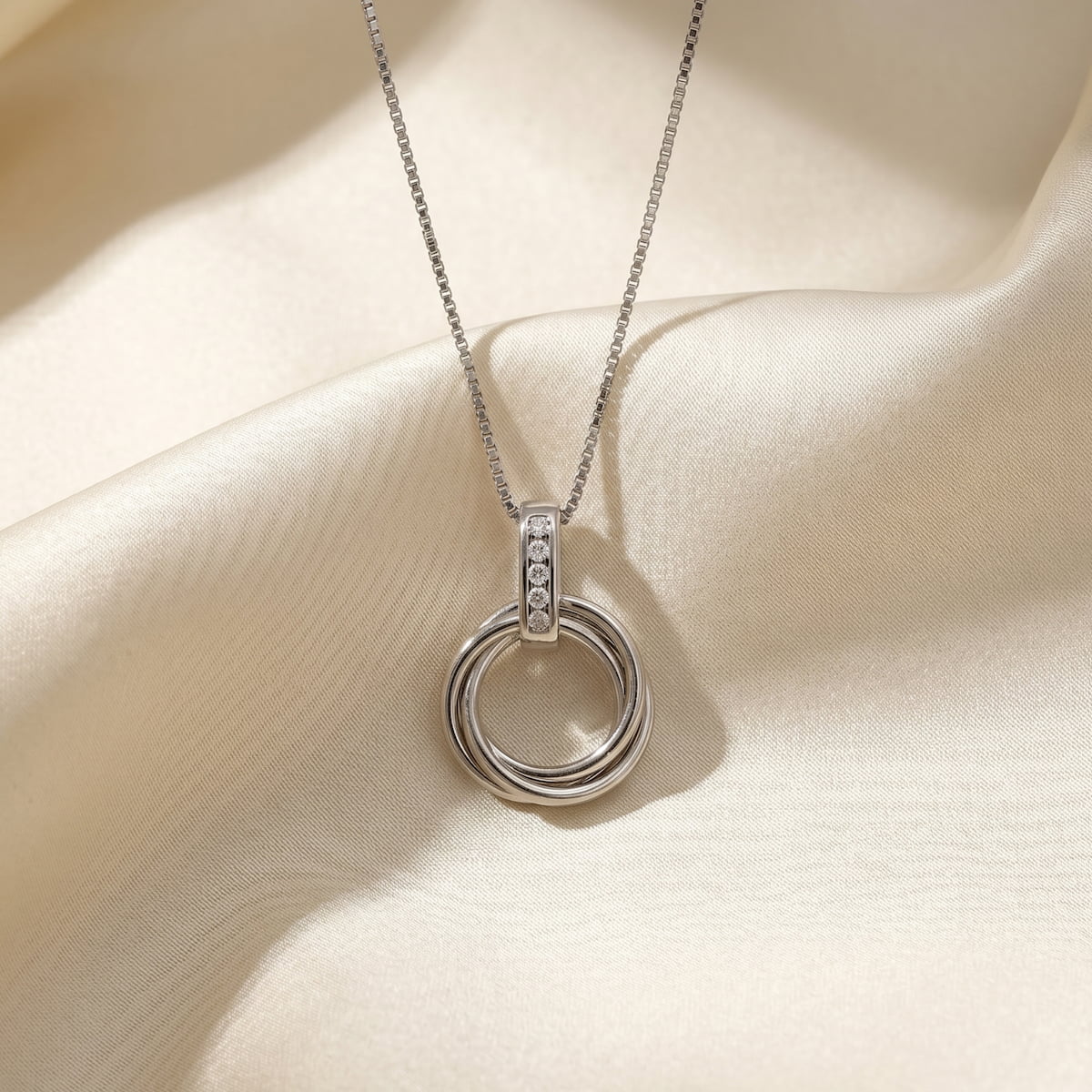 Sterling silver pendant featuring an elegant intertwined knot design accented with three lab-grown diamonds, suspended on a fine silver chain for a modern and sculptural look.